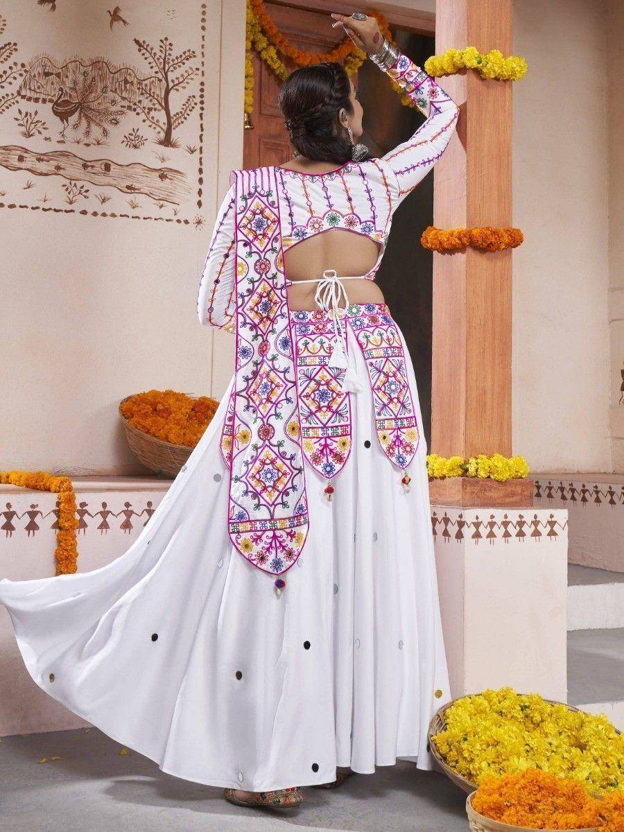 White embroidered ethnic gown with colorful mirror work, perfect for Indian festivals and celebrations