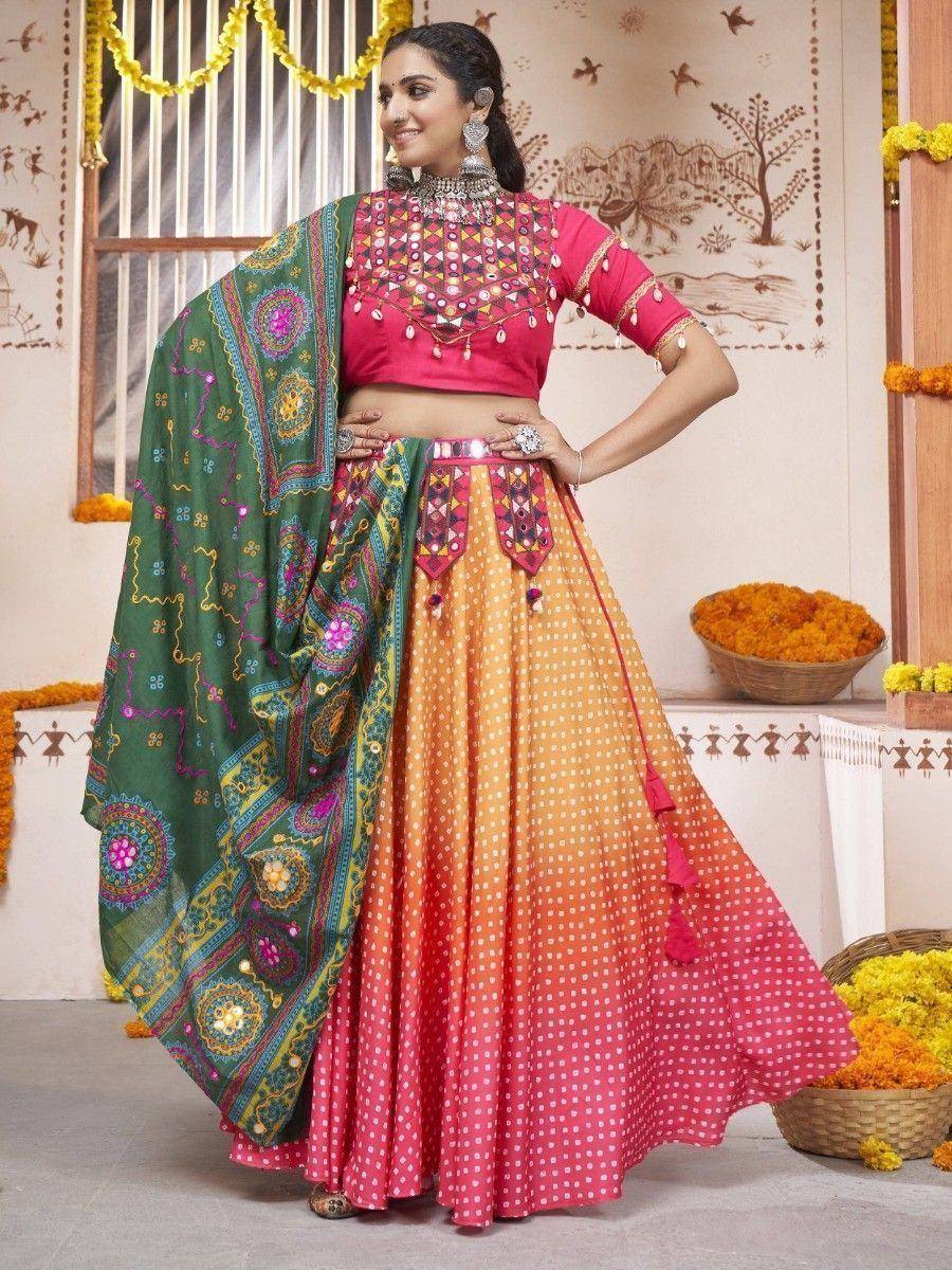 Vibrant pink and orange polka dot lehenga choli with green embroidered dupatta, perfect for Indian ethnic occasions.