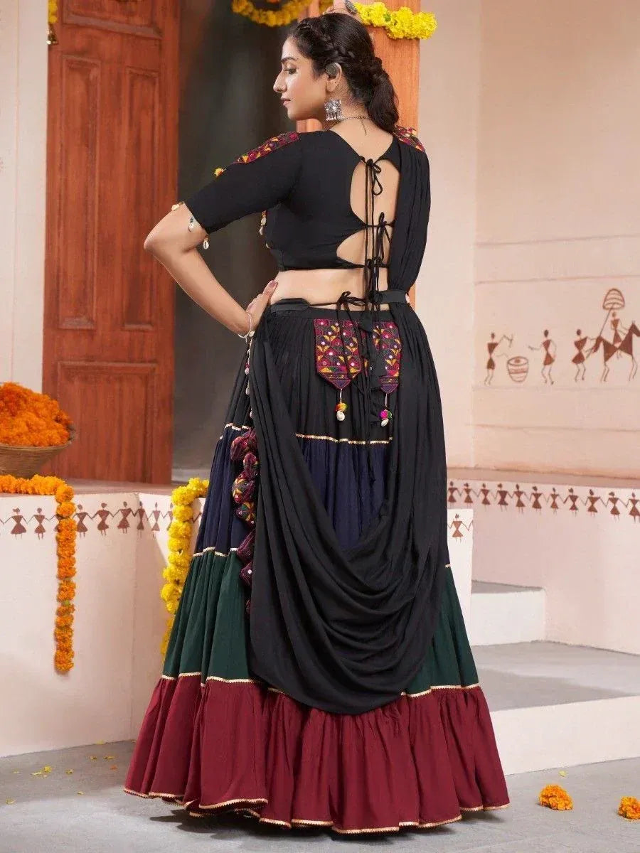 Black backless blouse with tie-up detail paired with multi-color layered lehenga skirt, ethnic wear
