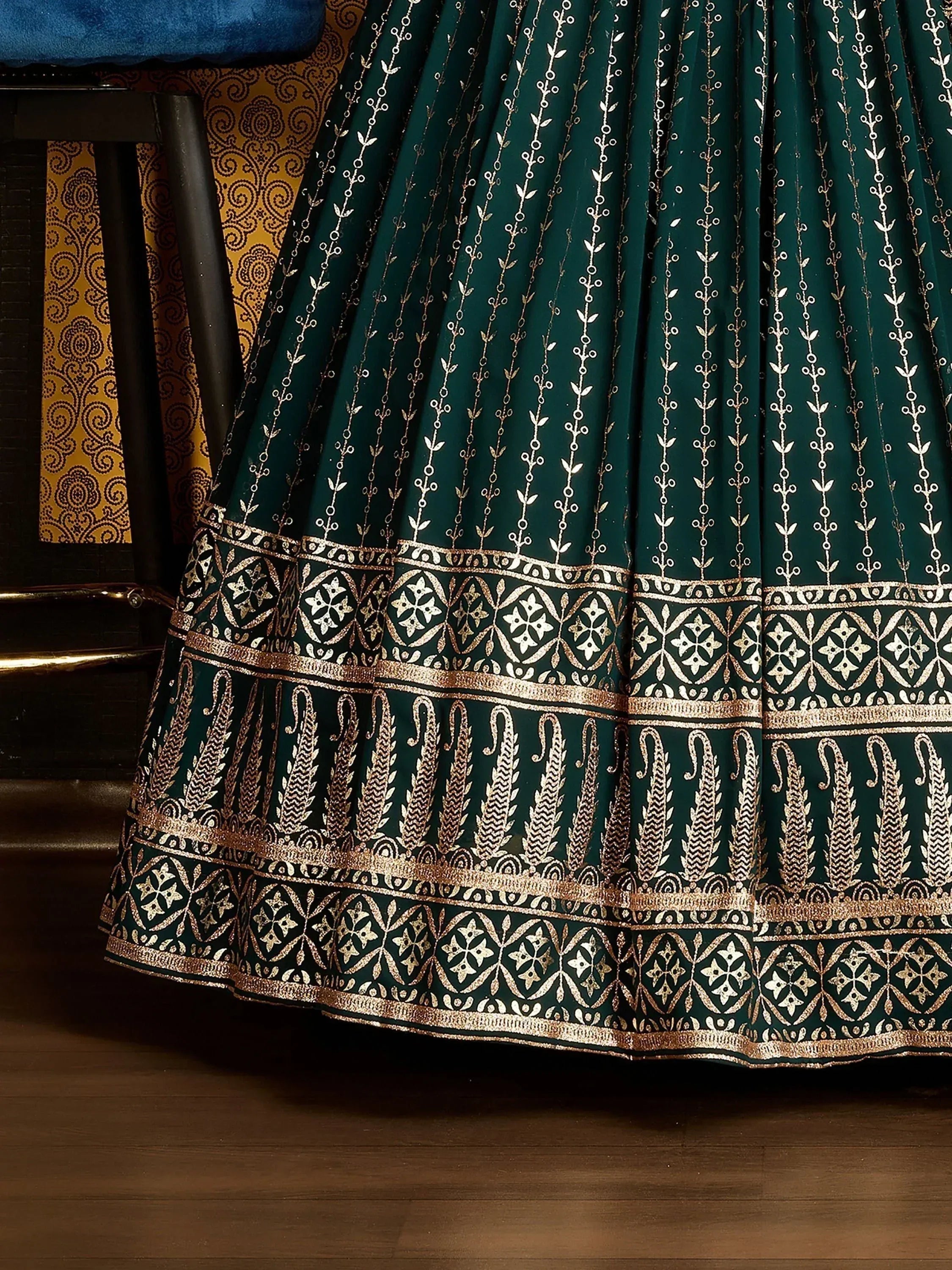 Emerald green lehenga skirt with gold floral embroidery and intricate border detailing, ethnic wear