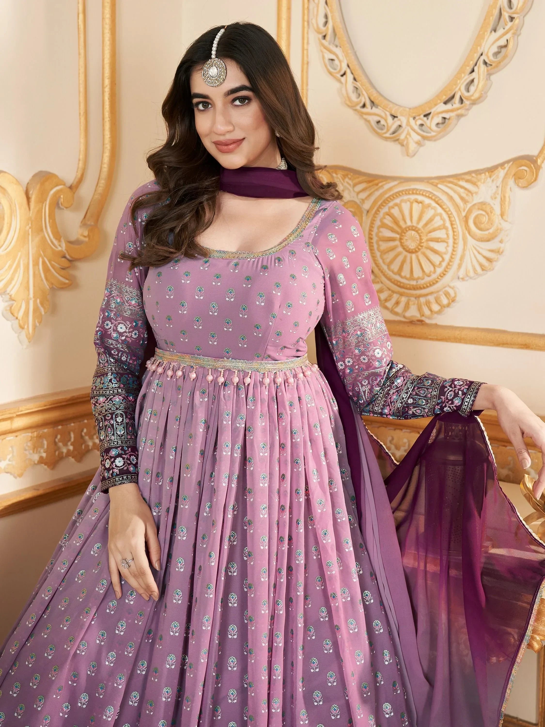 Woman in mauve embroidered anarkali suit with sheer dupatta, traditional Indian attire