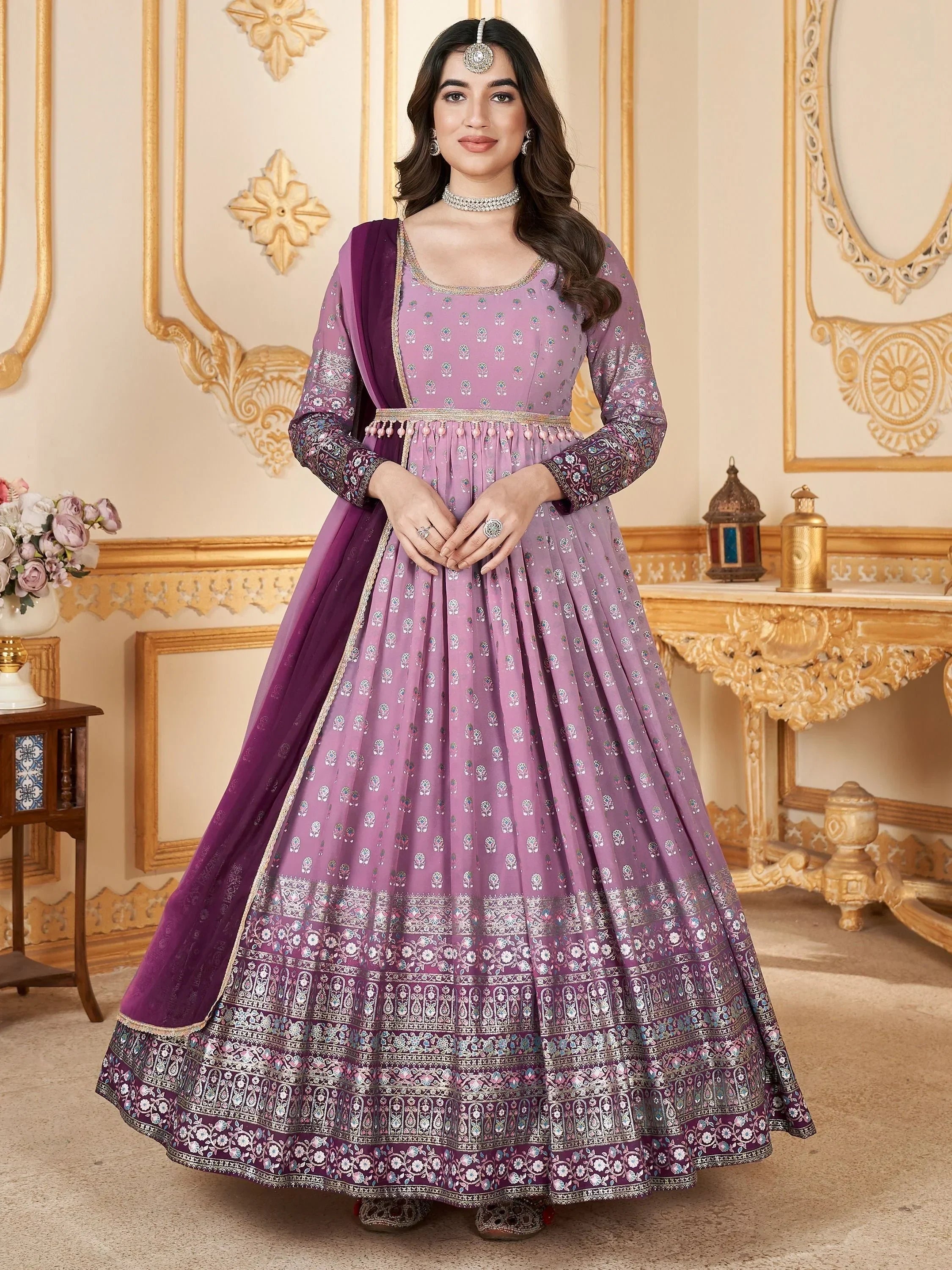 Woman in designer mauve ethnic gown with silver embroidery and dupatta, traditional jewelry