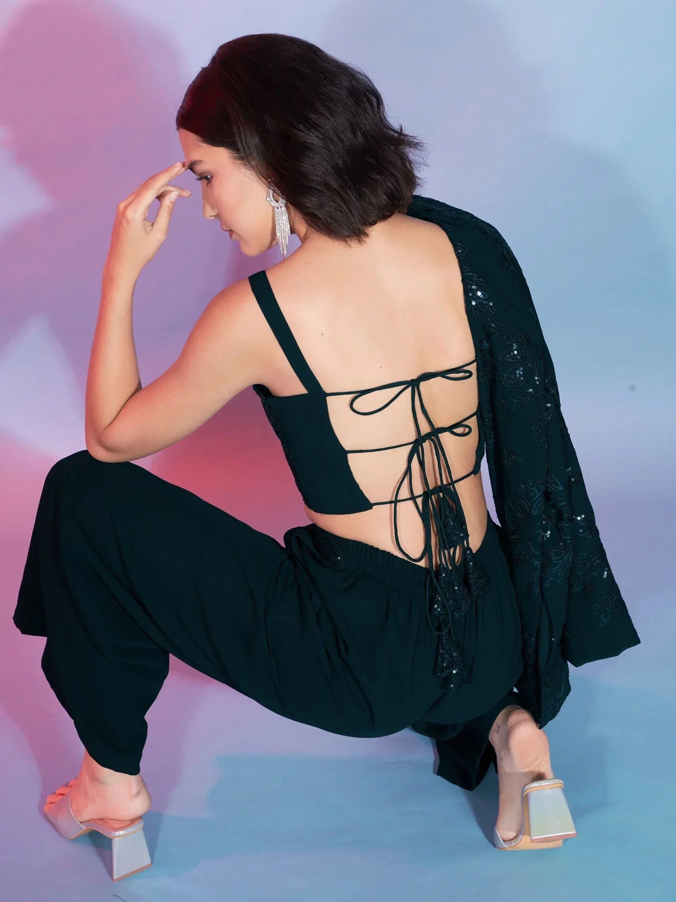 Black ethnic crop top with back lace-up detail, paired with palazzo pants and sequin shrug for festive wear
