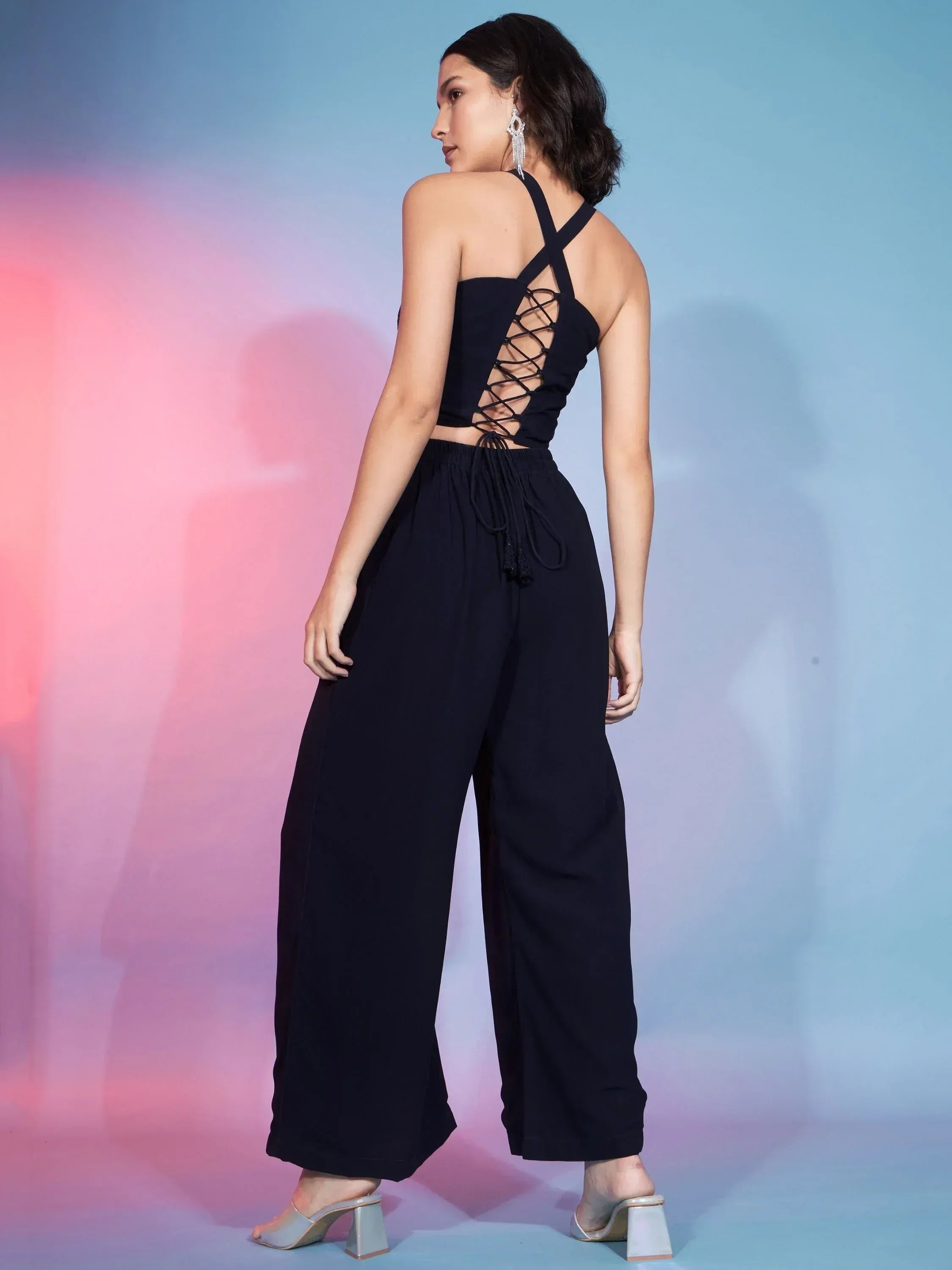 Black backless halter top with lace-up detail paired with wide-leg pants, stylish ethnic wear
