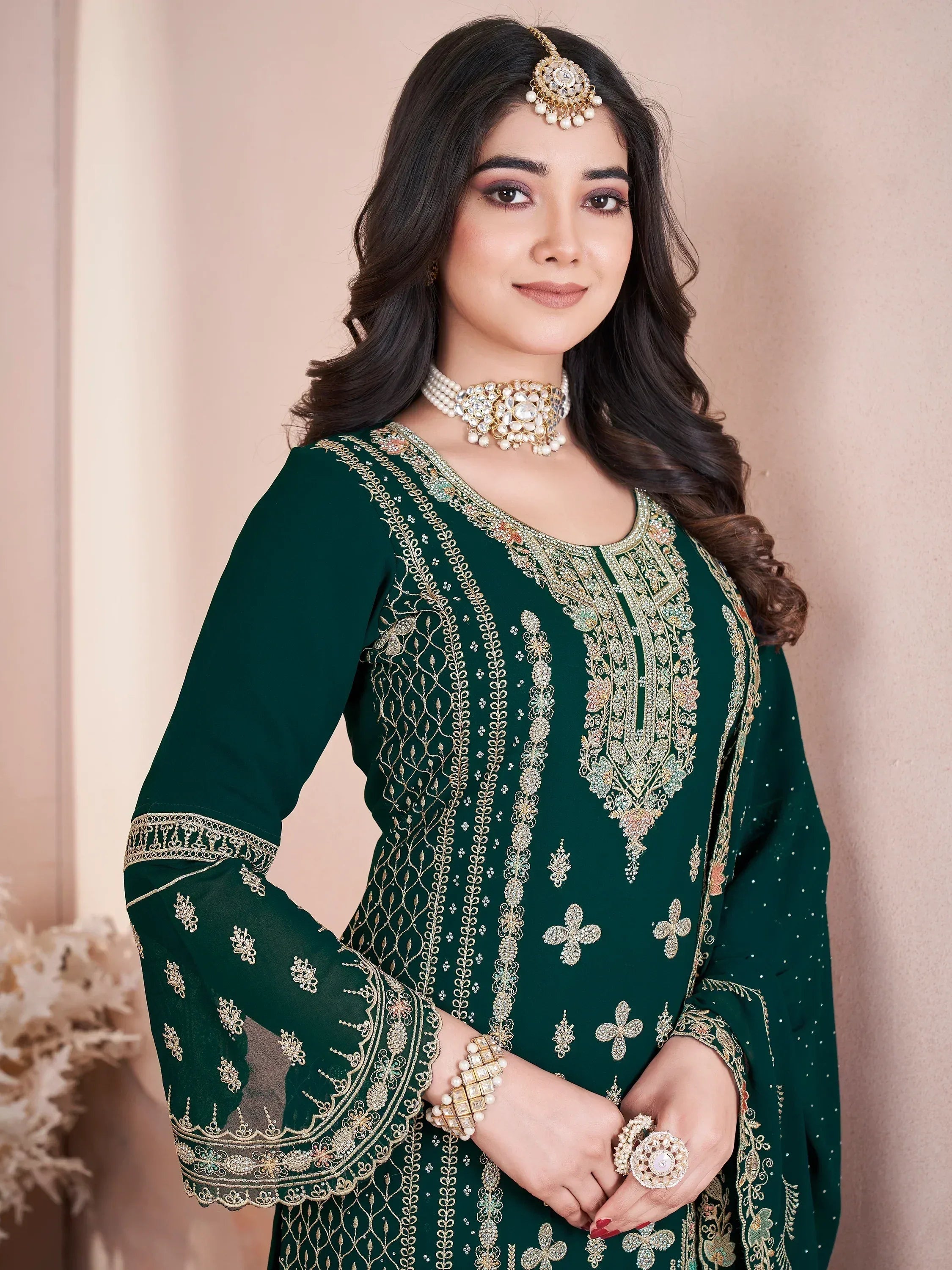 Emerald green embroidered ethnic kurti with gold detailing, paired with traditional jewelry for festive occasions.