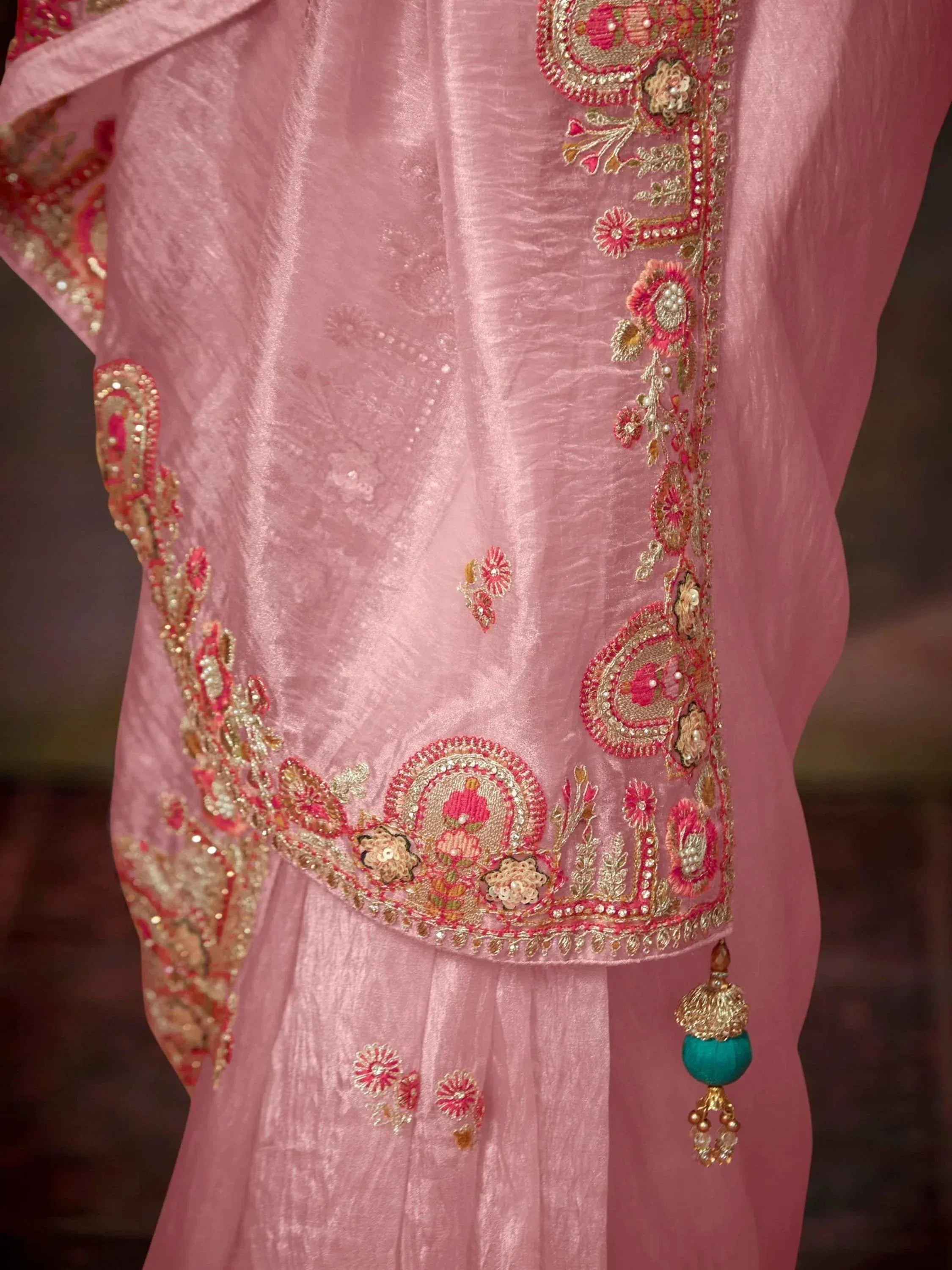 Pink ethnic gown with gold and pink floral embroidery, sequins, and tassel detail