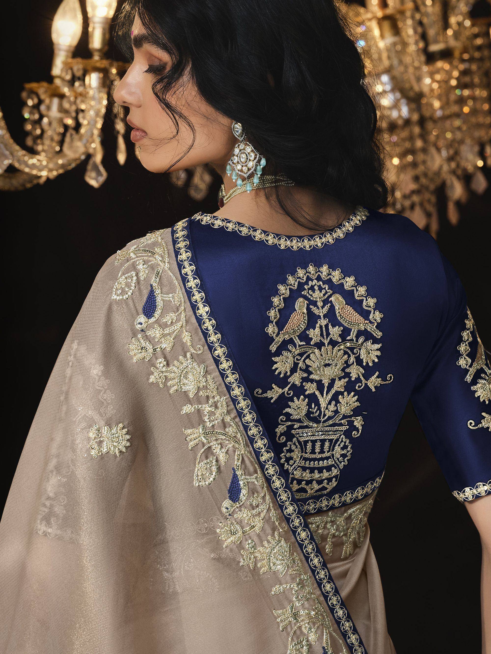 Elegant navy blue and beige ethnic saree with intricate gold bird embroidery, perfect for Indian weddings or festive occasions.