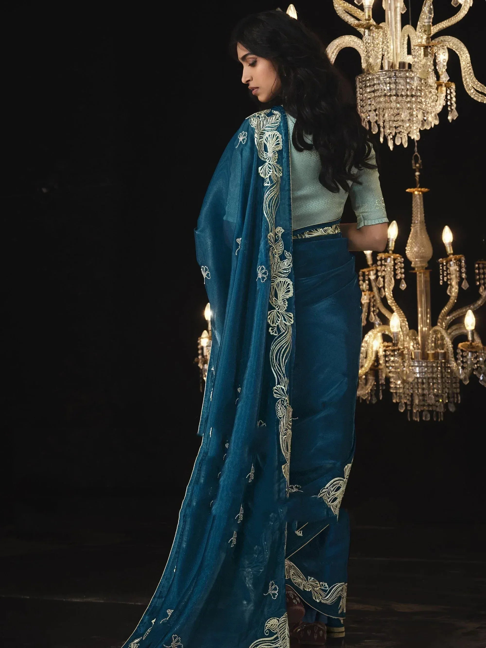 Elegant teal saree with gold embroidery, styled with a light blue blouse, perfect for Indian ethnic occasions.