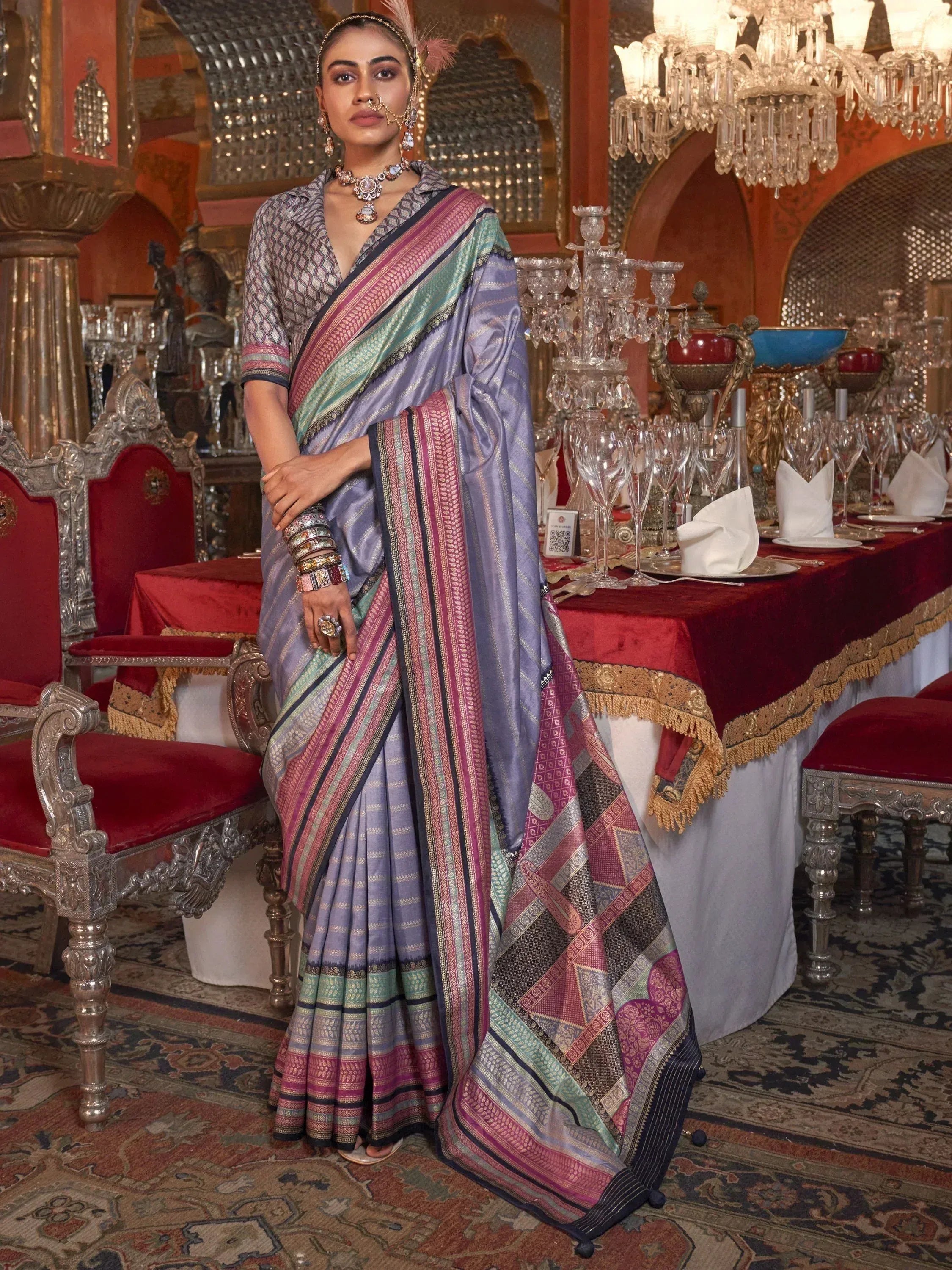 Elegant woman in purple and pink designer saree with intricate patterns, styled for festive occasions.