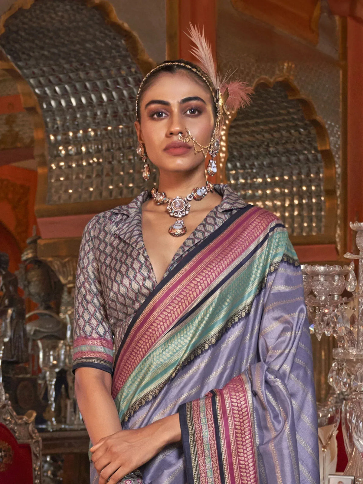 Elegant woman in purple saree with intricate patterns and traditional jewelry, showcasing Indian ethnic wear.