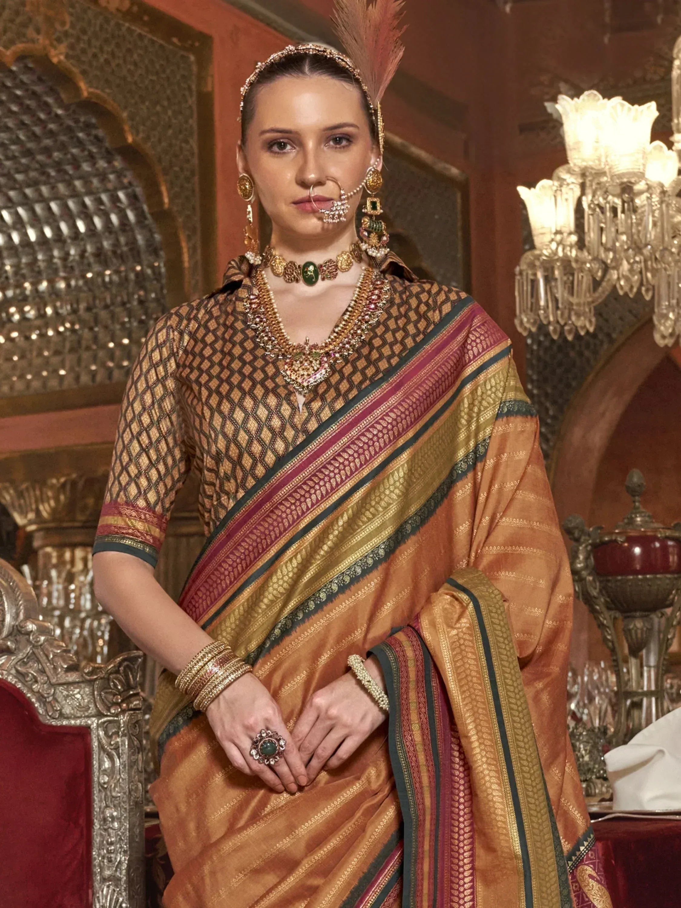 Elegant Indian saree with gold embroidery, traditional jewelry, and ornate feather headpiece for festive occasions