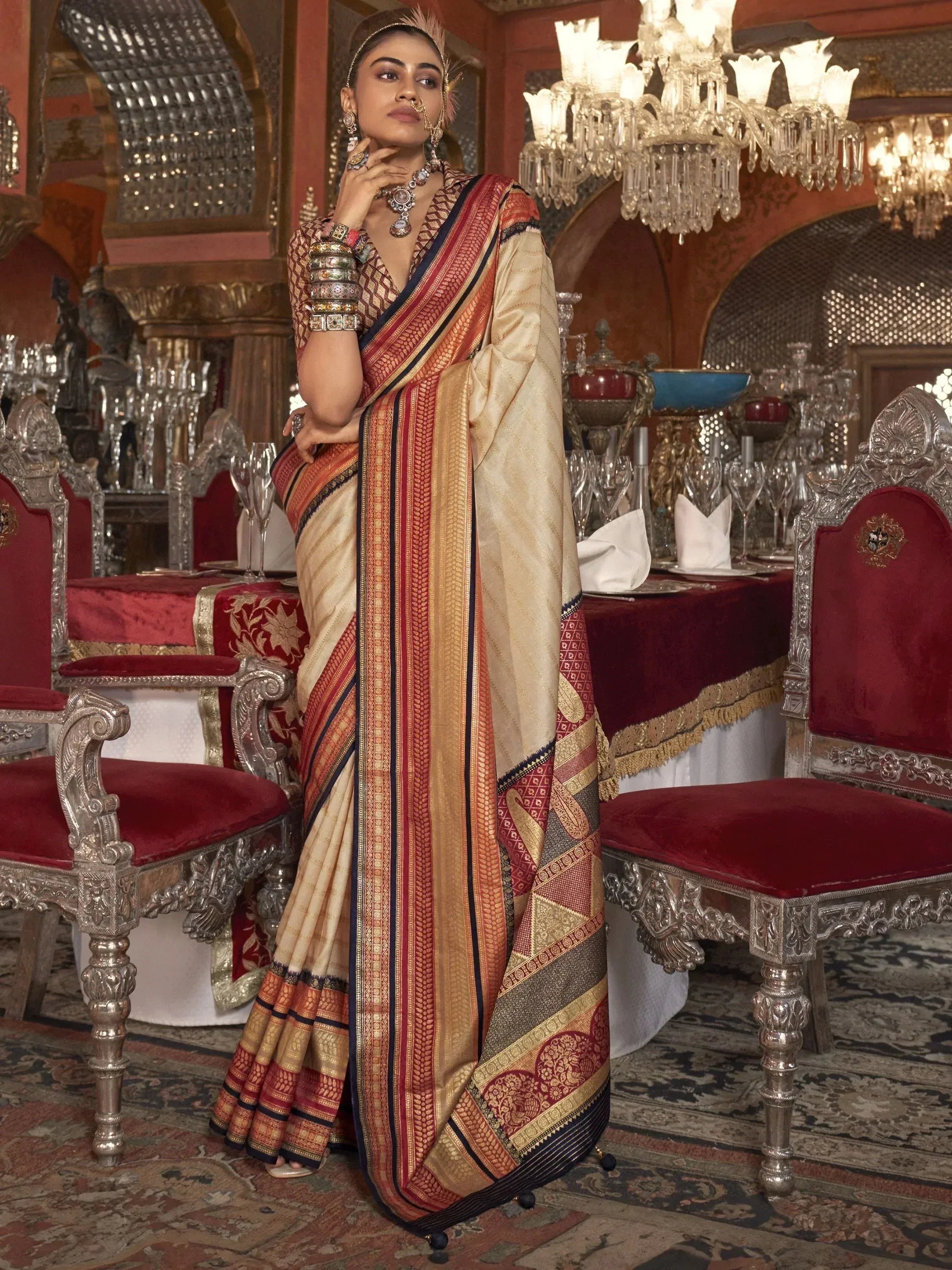 Elegant woman in traditional Indian saree with gold and red borders, styled for festive occasions.