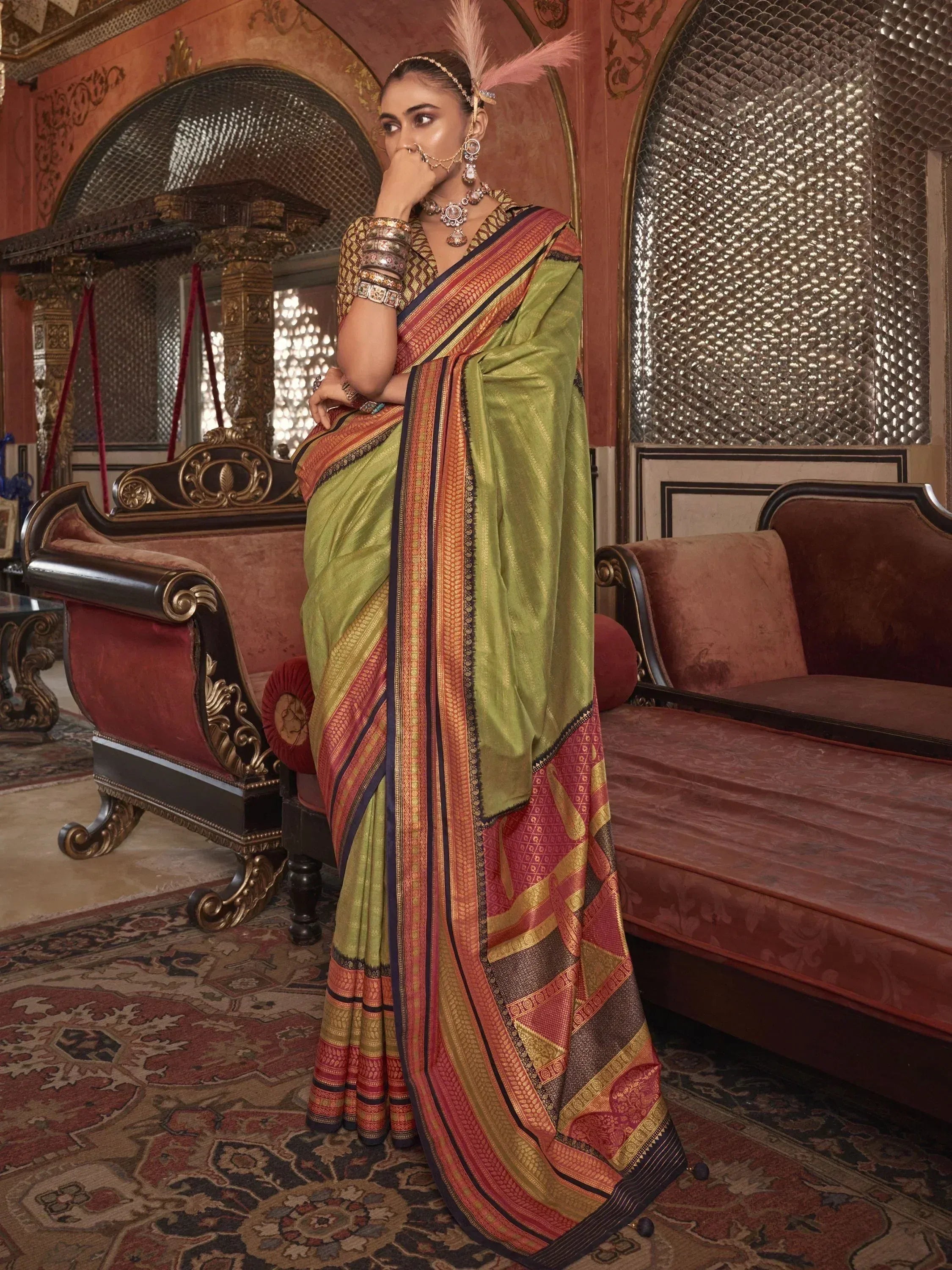 Woman in olive green and red designer saree with gold embroidery, traditional Indian ethnic wear