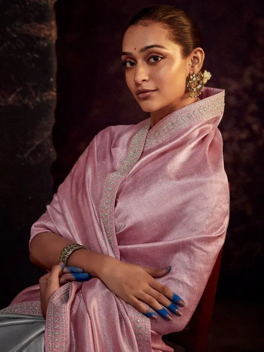 Pink embroidered saree with silver detailing, styled with statement earrings and blue nail art