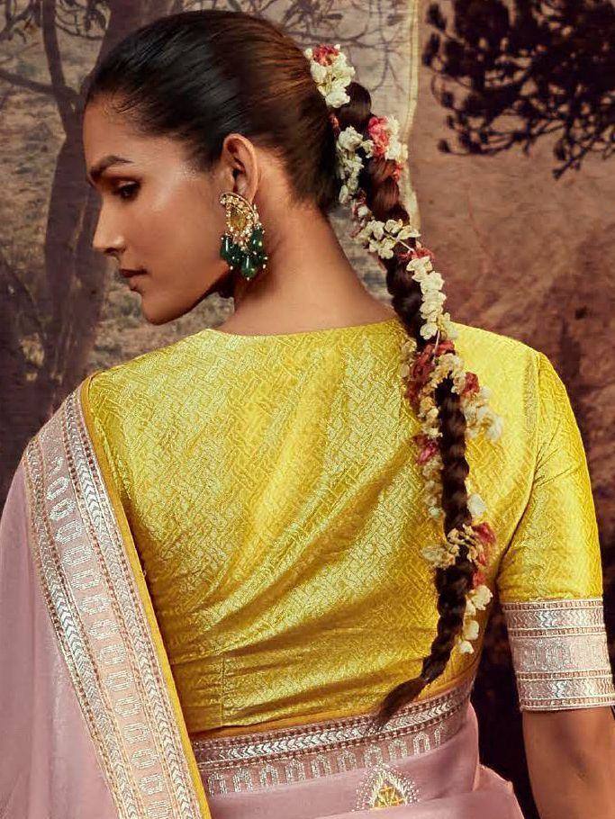Yellow designer blouse with pink saree, floral braid, and statement earrings for ethnic wear