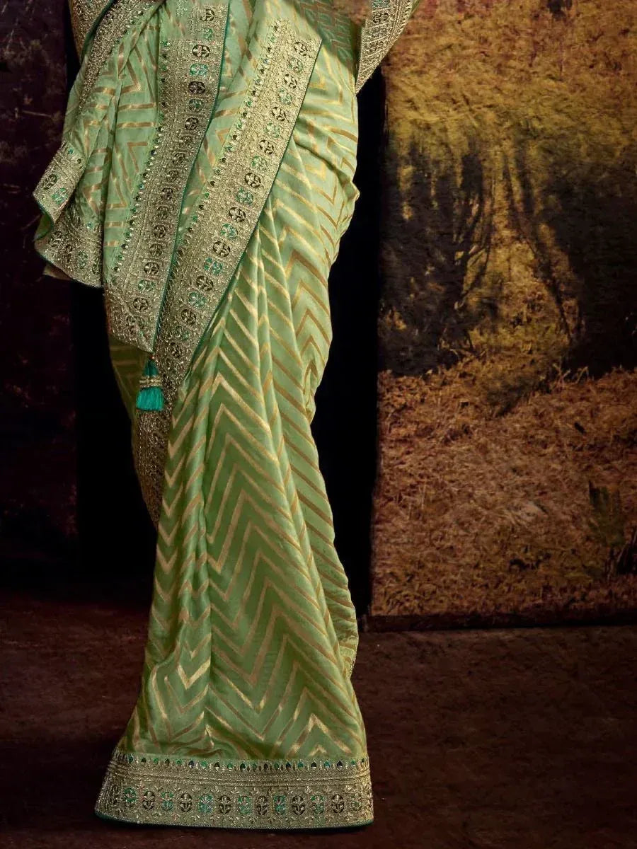 Mint green saree with gold zigzag print and embroidered border, perfect for ethnic occasions