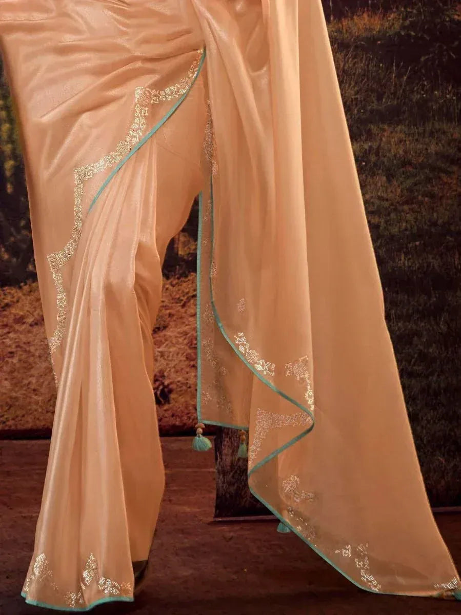 Elegant peach saree with gold embroidery and teal border, perfect for Indian ethnic wear occasions