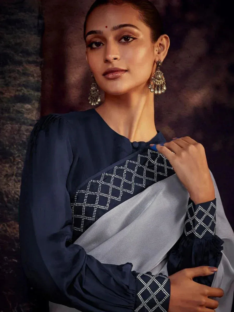 Elegant navy blue and silver saree with geometric embroidery, paired with statement earrings for Indian ethnic wear.