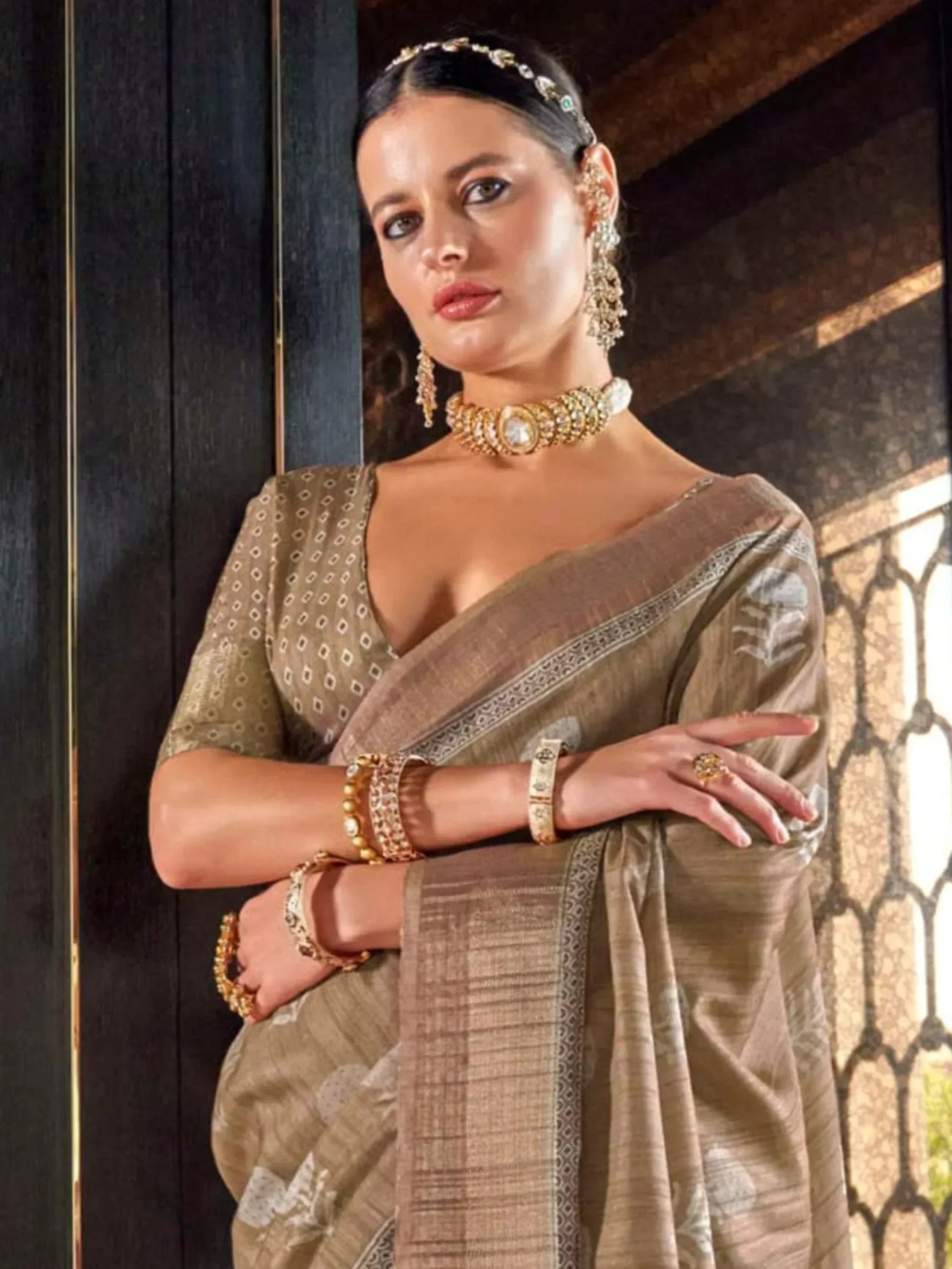 Elegant woman in olive green saree with gold jewelry, traditional Indian ethnic wear