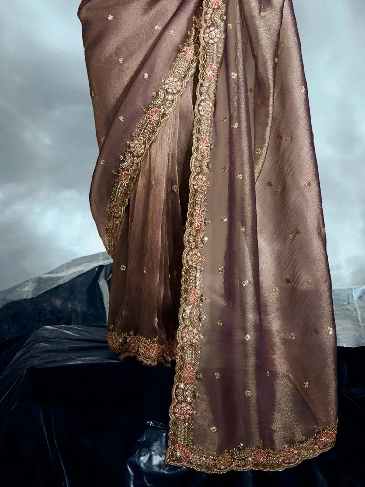 Elegant brown saree with gold and pink floral embroidery, perfect for ethnic wear occasions.