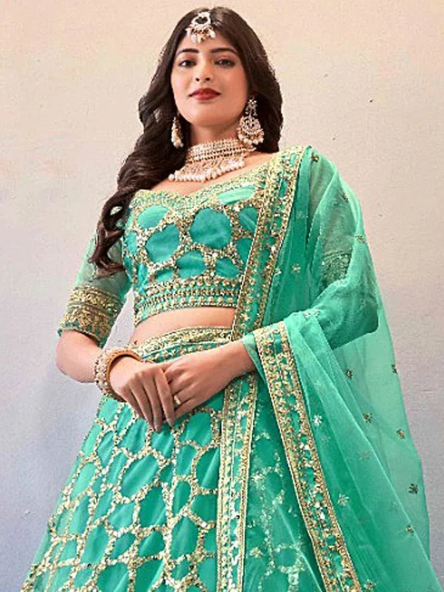 Emerald green designer lehenga choli with gold embroidery and sheer dupatta, perfect for Indian weddings and festive occasions.