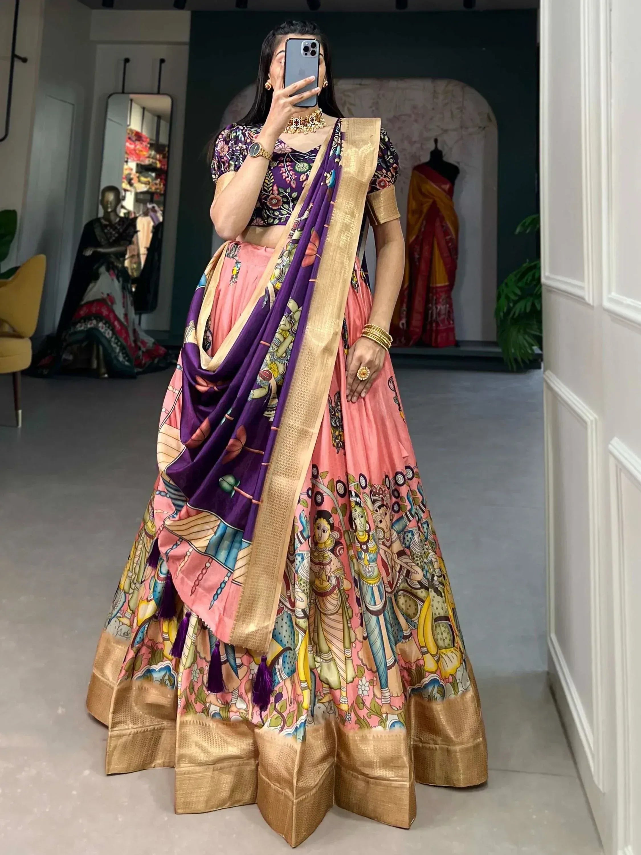 Woman in pink and purple printed lehenga choli with gold border, ethnic Indian wear for festive occasions
