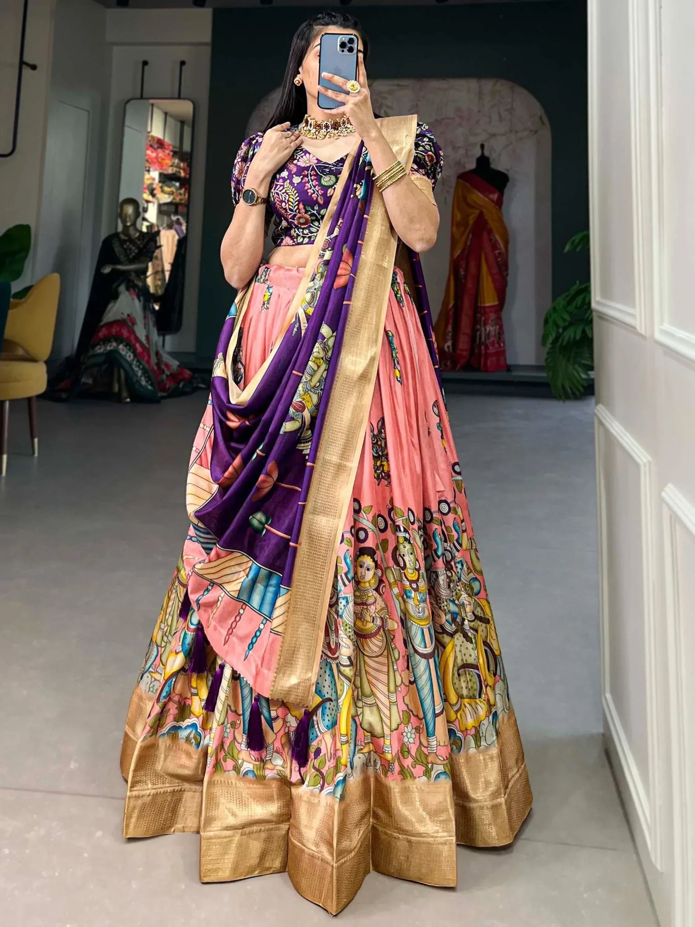 Woman in vibrant pink and purple printed lehenga choli with gold border, perfect for Indian ethnic wear occasions