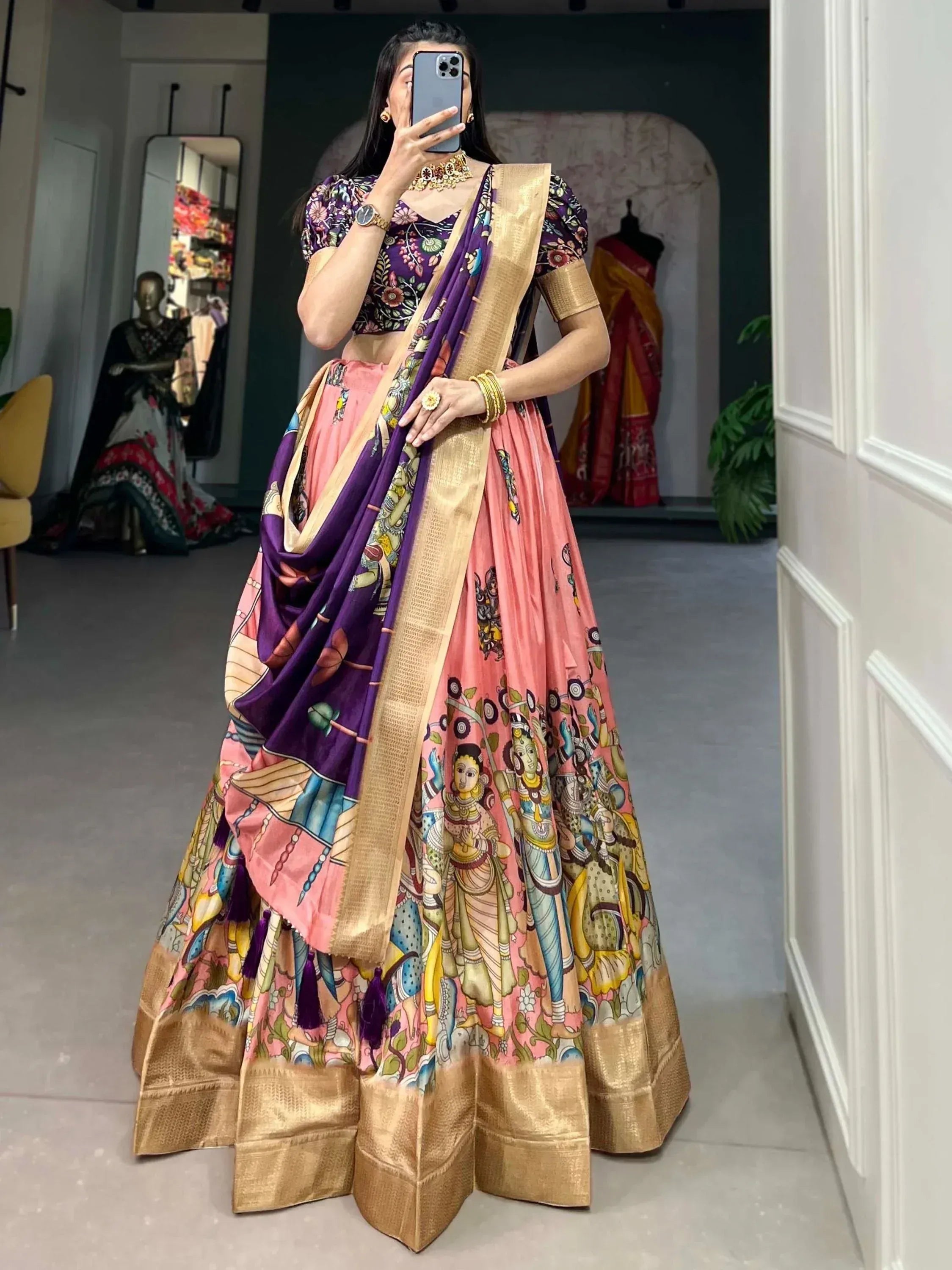 Woman in vibrant pink and purple printed lehenga choli with gold border, perfect for Indian ethnic occasions