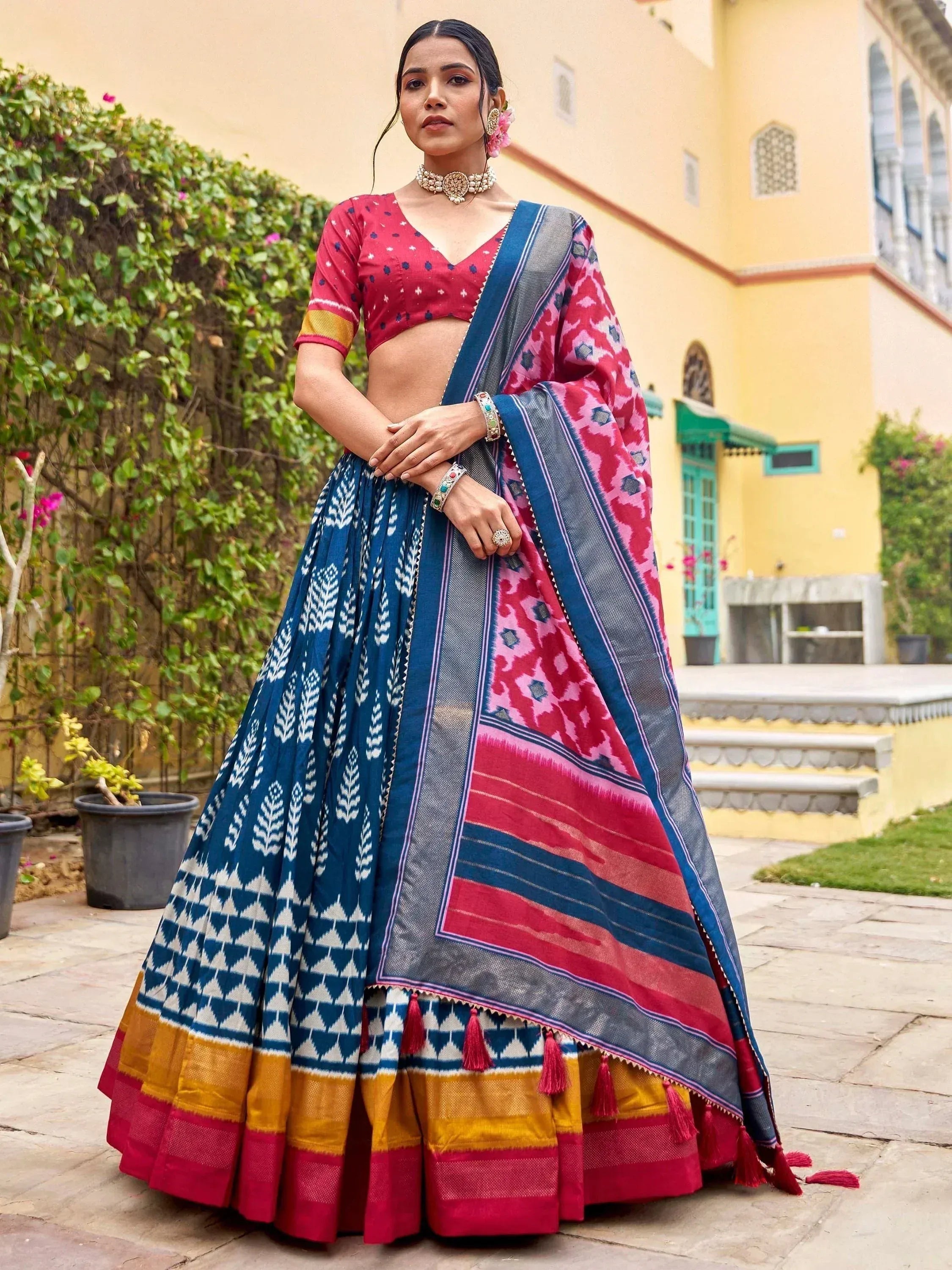 Woman in vibrant blue and pink printed lehenga choli with tassels, perfect for Indian ethnic occasions