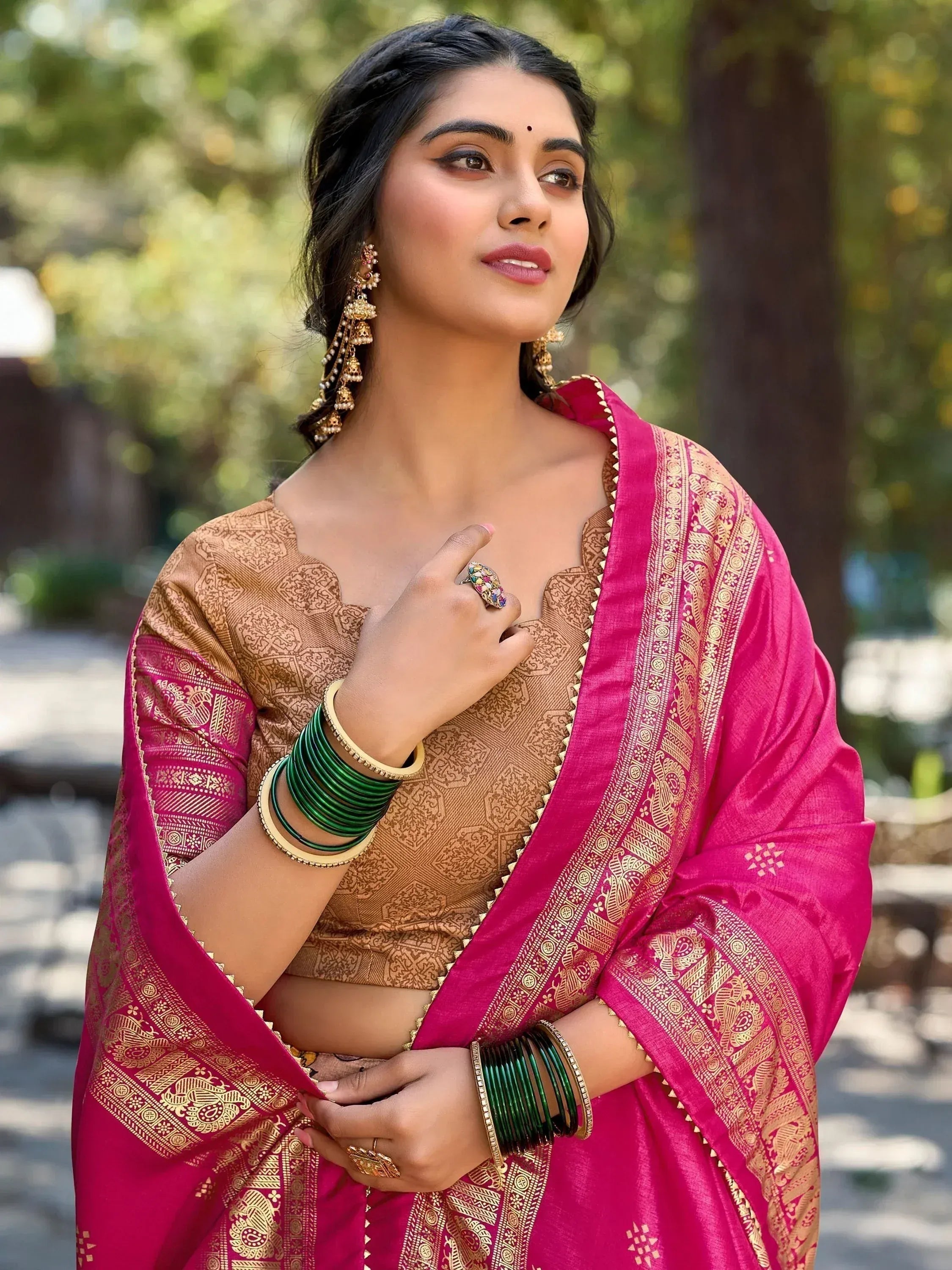 Woman in pink and gold ethnic saree with traditional jewelry, perfect for Indian festive occasions