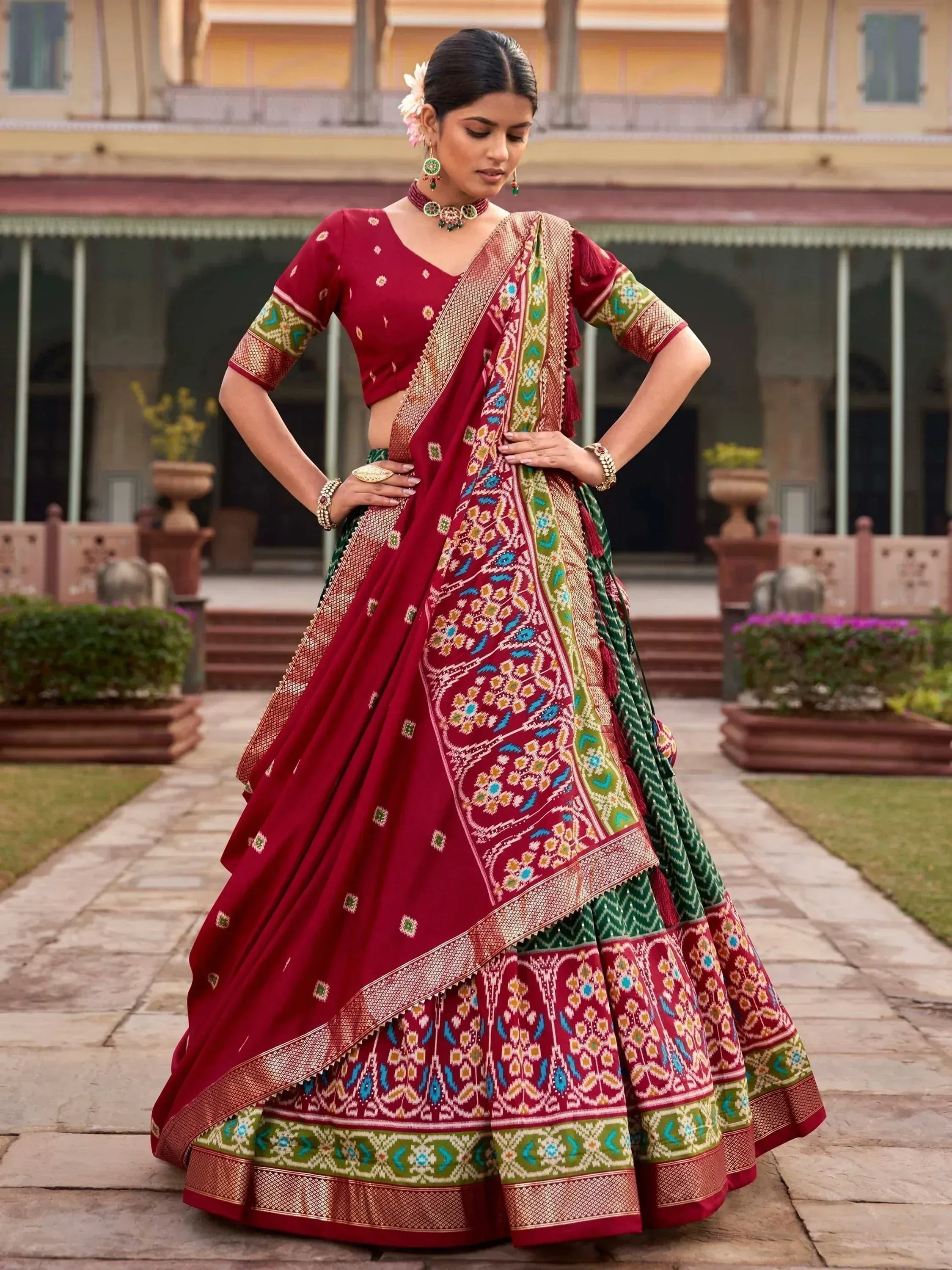 Red and green designer lehenga choli with intricate embroidery, perfect for Indian ethnic wear occasions.
