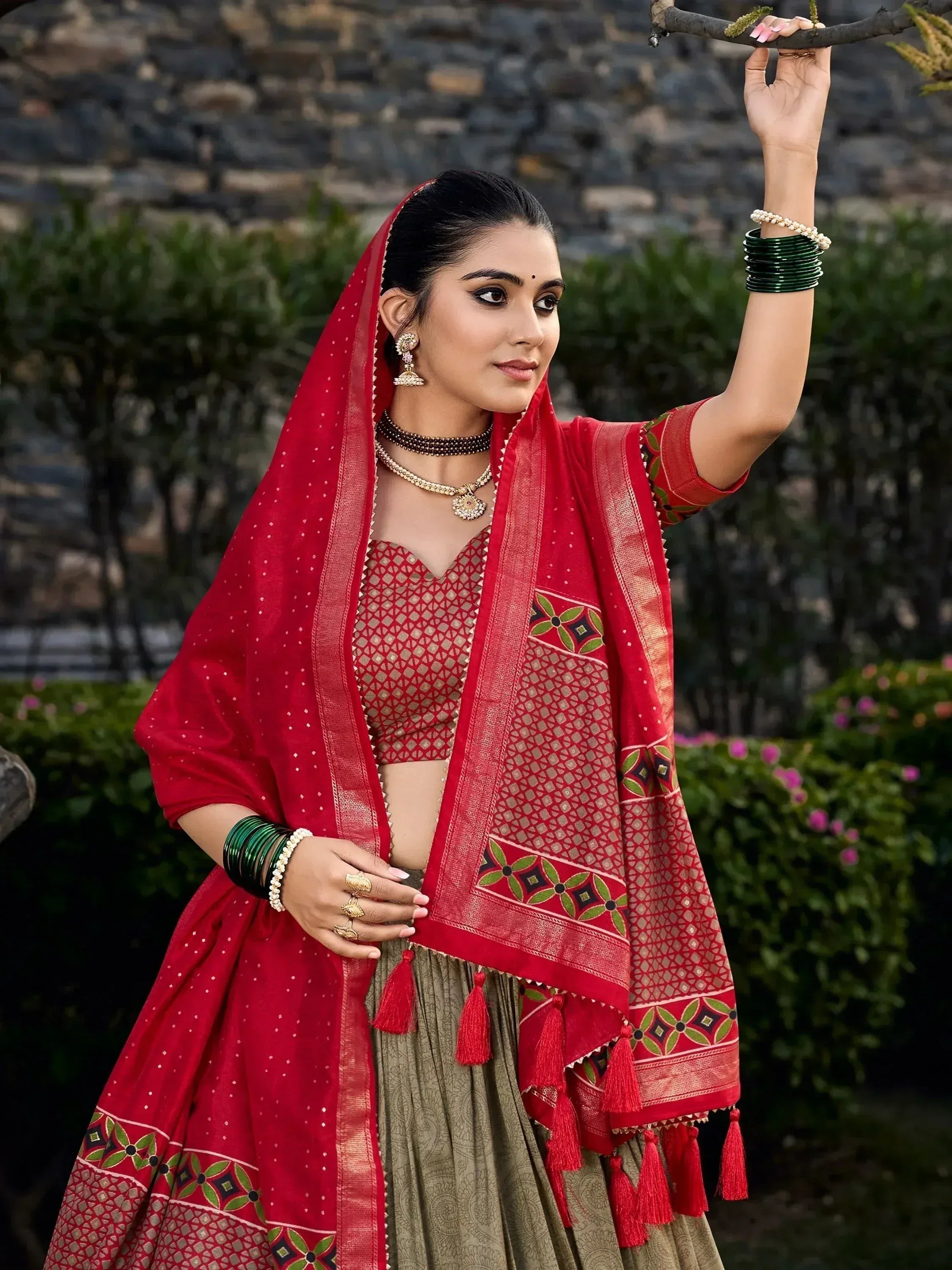 Red and green ethnic lehenga choli with embroidered dupatta, perfect for Indian weddings and festive occasions.