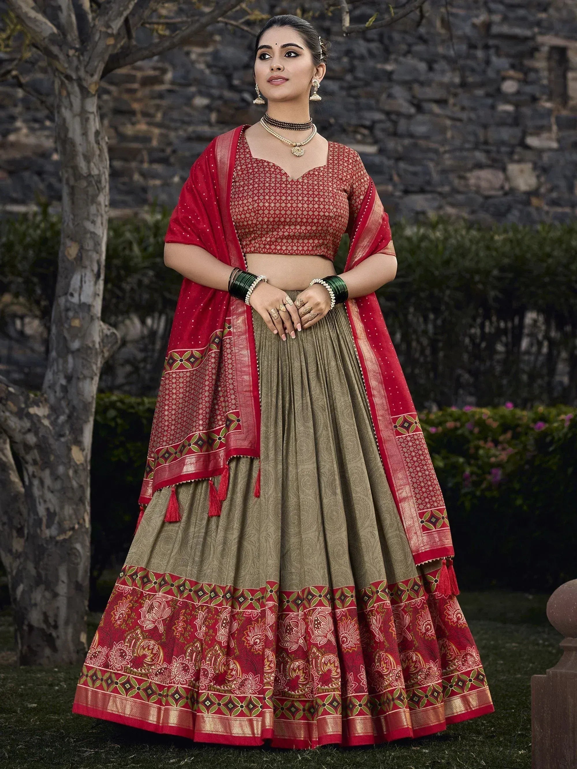 Red and olive green designer lehenga choli with intricate patterns, perfect for Indian ethnic wear occasions.