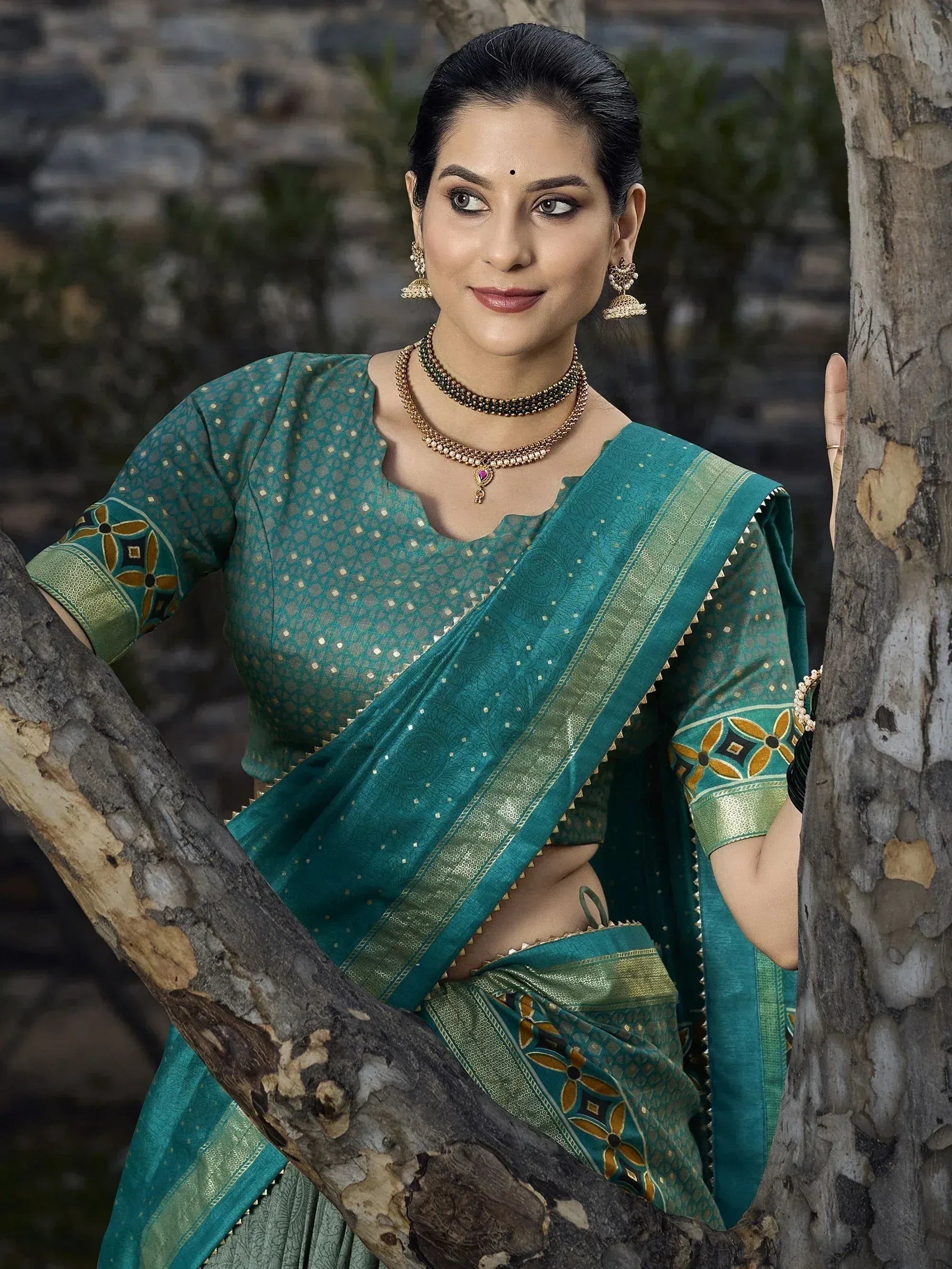 Woman in teal designer saree with gold embroidery, traditional Indian ethnic wear, perfect for festive occasions