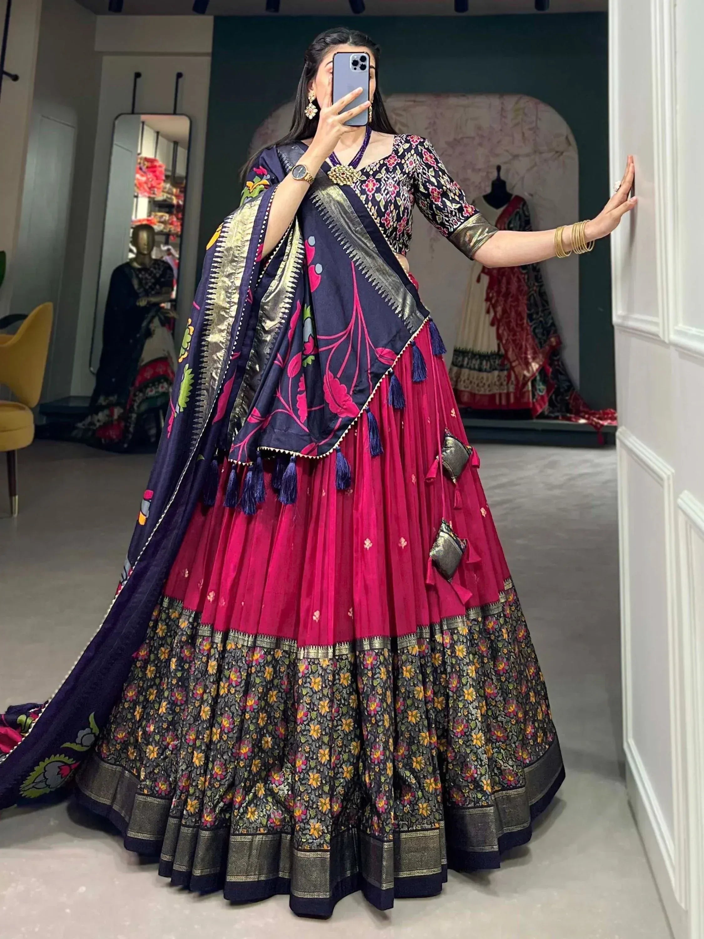 Woman in vibrant pink and navy floral lehenga choli with embroidered dupatta, perfect for Indian ethnic occasions.