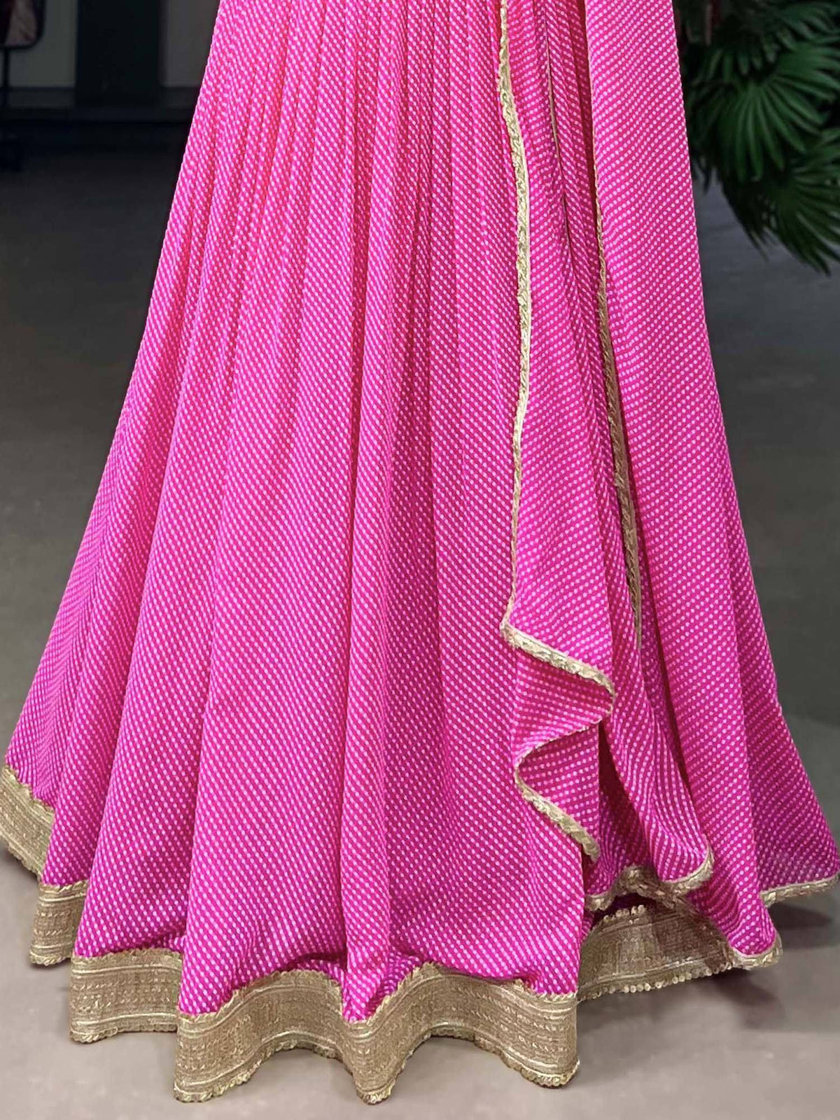 Vibrant pink lehenga with white polka dots and gold border, ideal for Indian ethnic wear occasions.