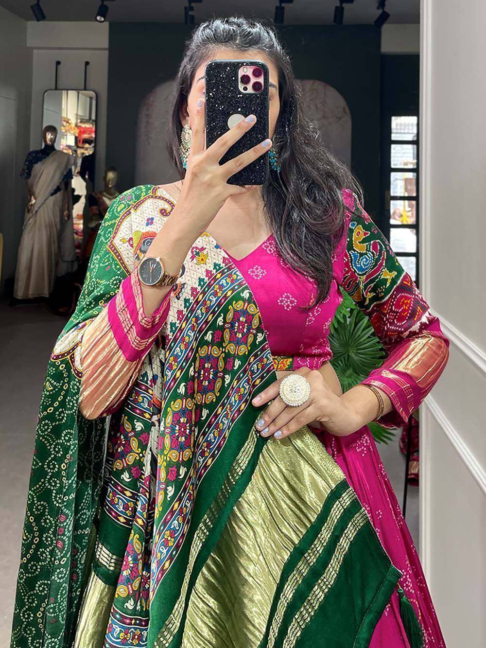 Woman in vibrant pink and green printed lehenga choli with ethnic dupatta, perfect for festive occasions.