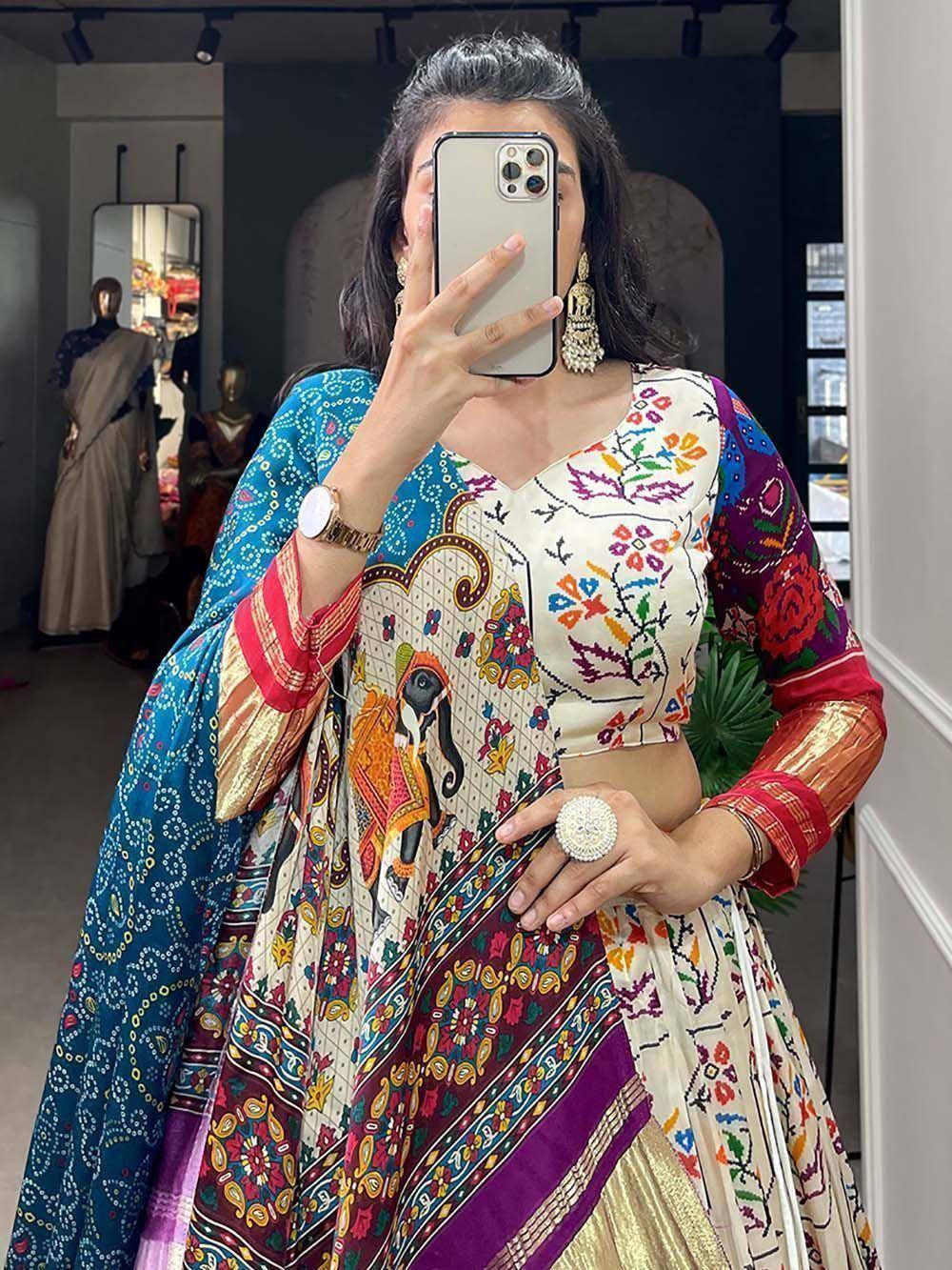 Woman in colorful embroidered lehenga choli with elephant print, mirror selfie in boutique