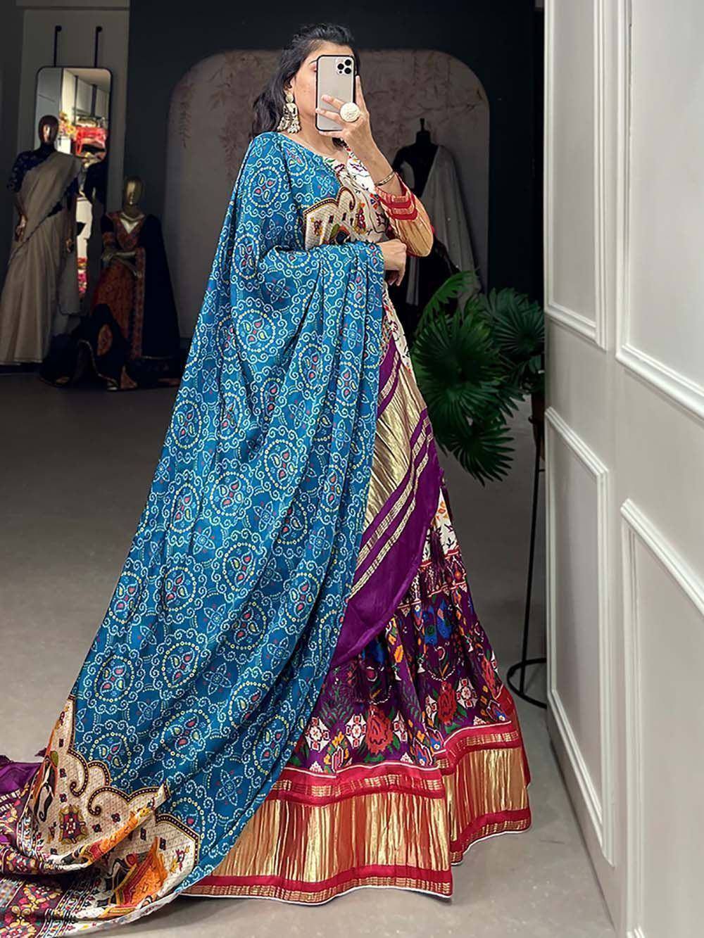 Woman in vibrant blue printed lehenga choli with purple and gold border, ethnic Indian wear
