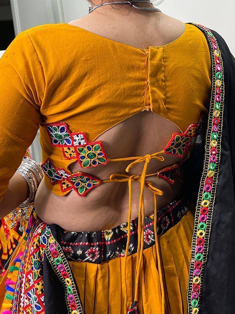 Yellow ethnic blouse with mirror work and back cutout, paired with embroidered lehenga and dupatta