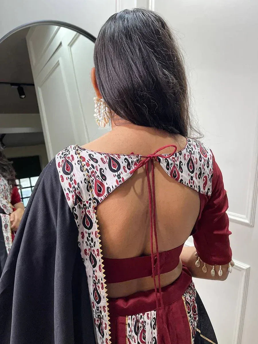 Back view of maroon and black ethnic lehenga choli with tie-up back and paisley print, perfect for Indian weddings.