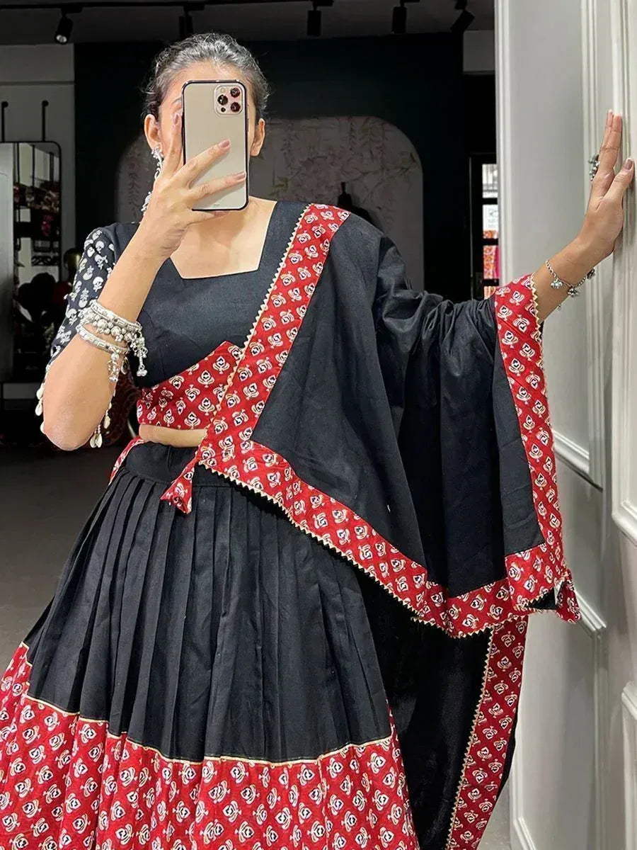 Black and red printed lehenga choli with pleated skirt and dupatta, styled for ethnic wear