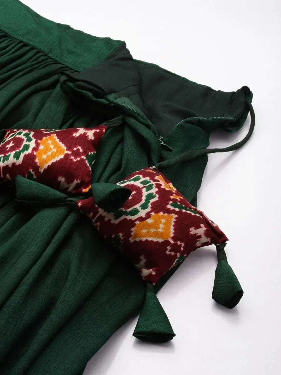 Emerald green ethnic gown with ikat print tie-up details and decorative tassels