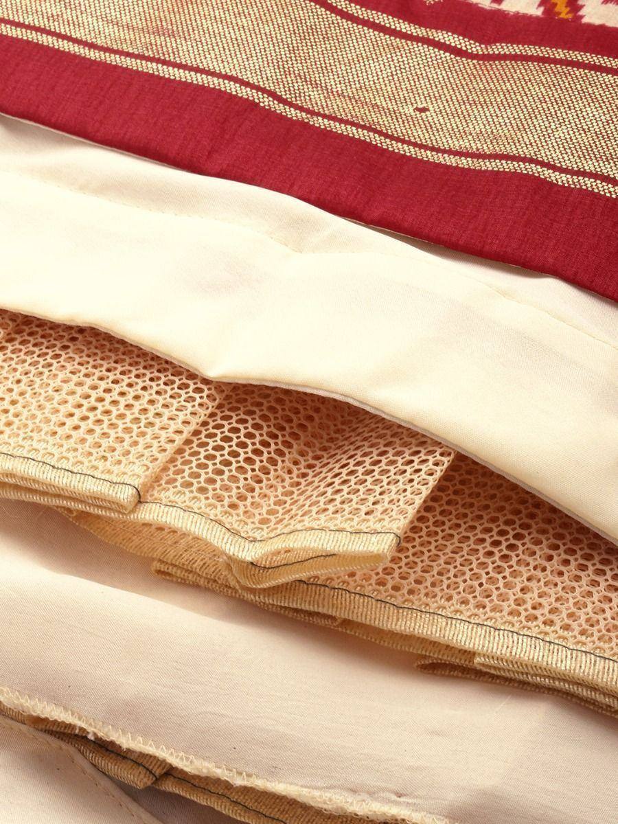 Close-up of layered ethnic wear fabric with red and beige patterns, mesh lining, and stitched details