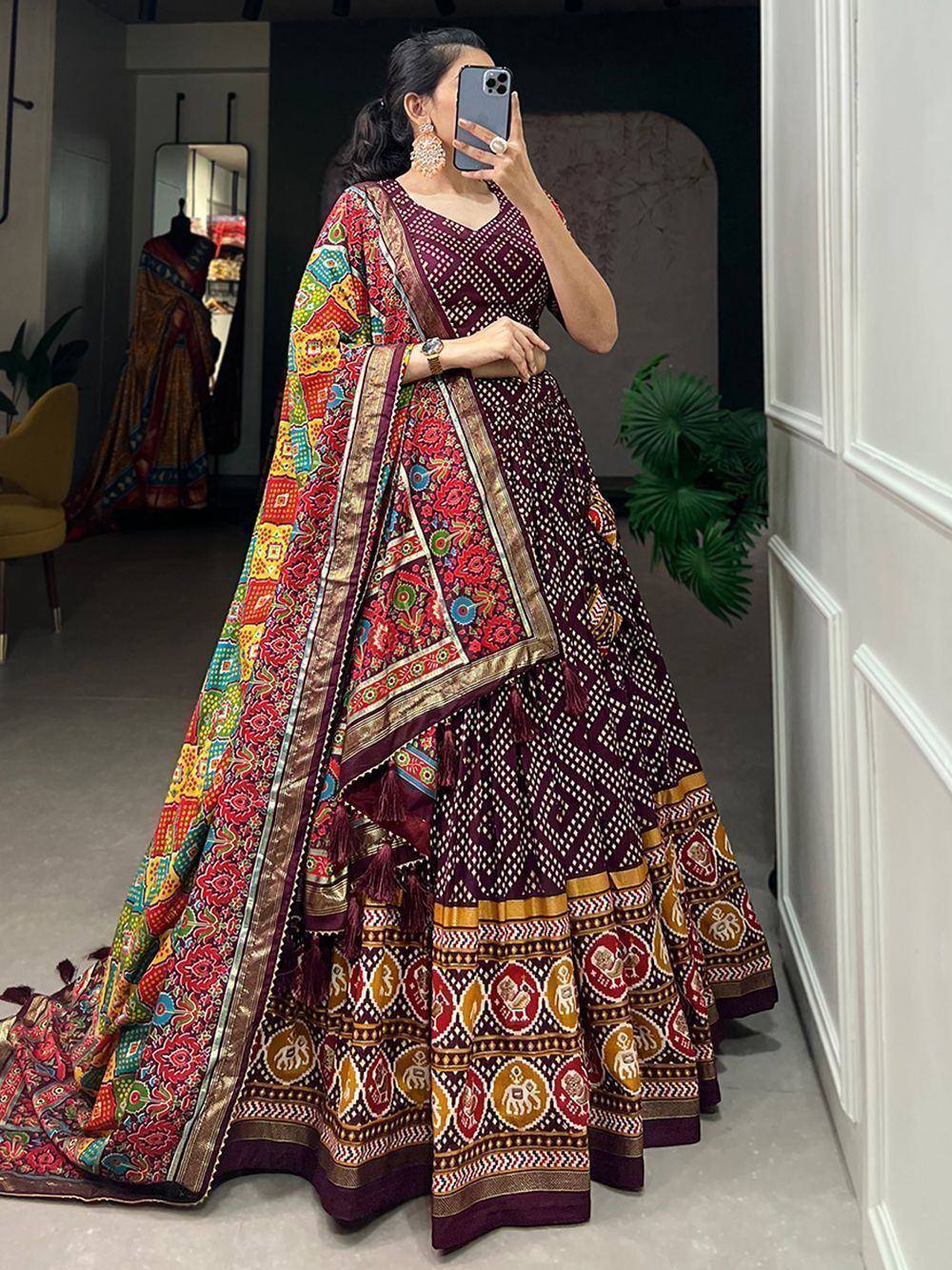 Woman in maroon printed lehenga choli with colorful dupatta, ethnic Indian wear for festive occasions