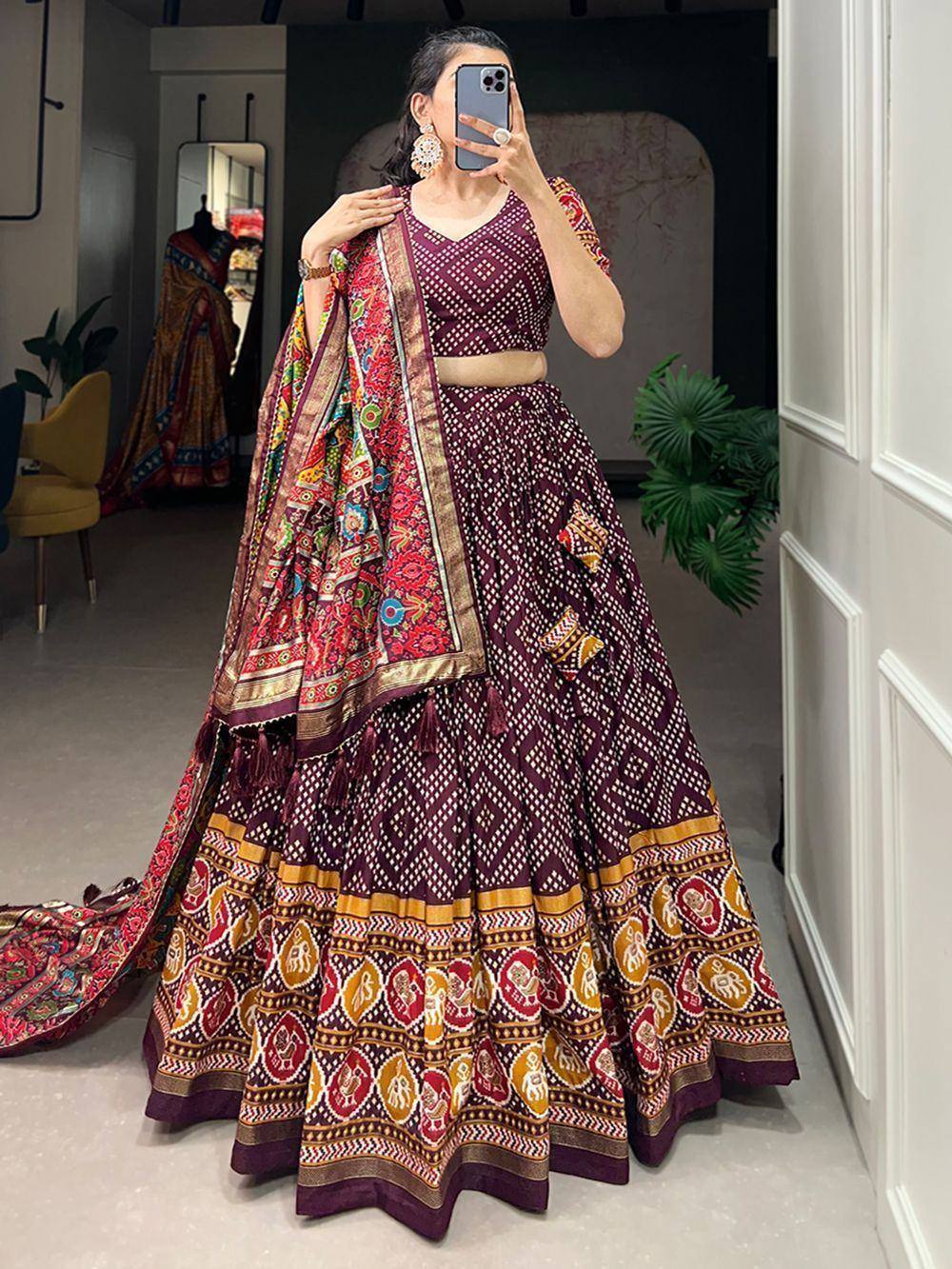 Woman wearing maroon printed lehenga choli with colorful dupatta, ethnic Indian wear