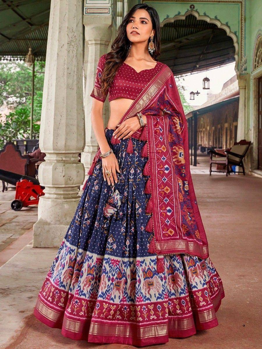 Woman in maroon and navy blue printed lehenga choli with ethnic patterns, perfect for Indian weddings or festivals
