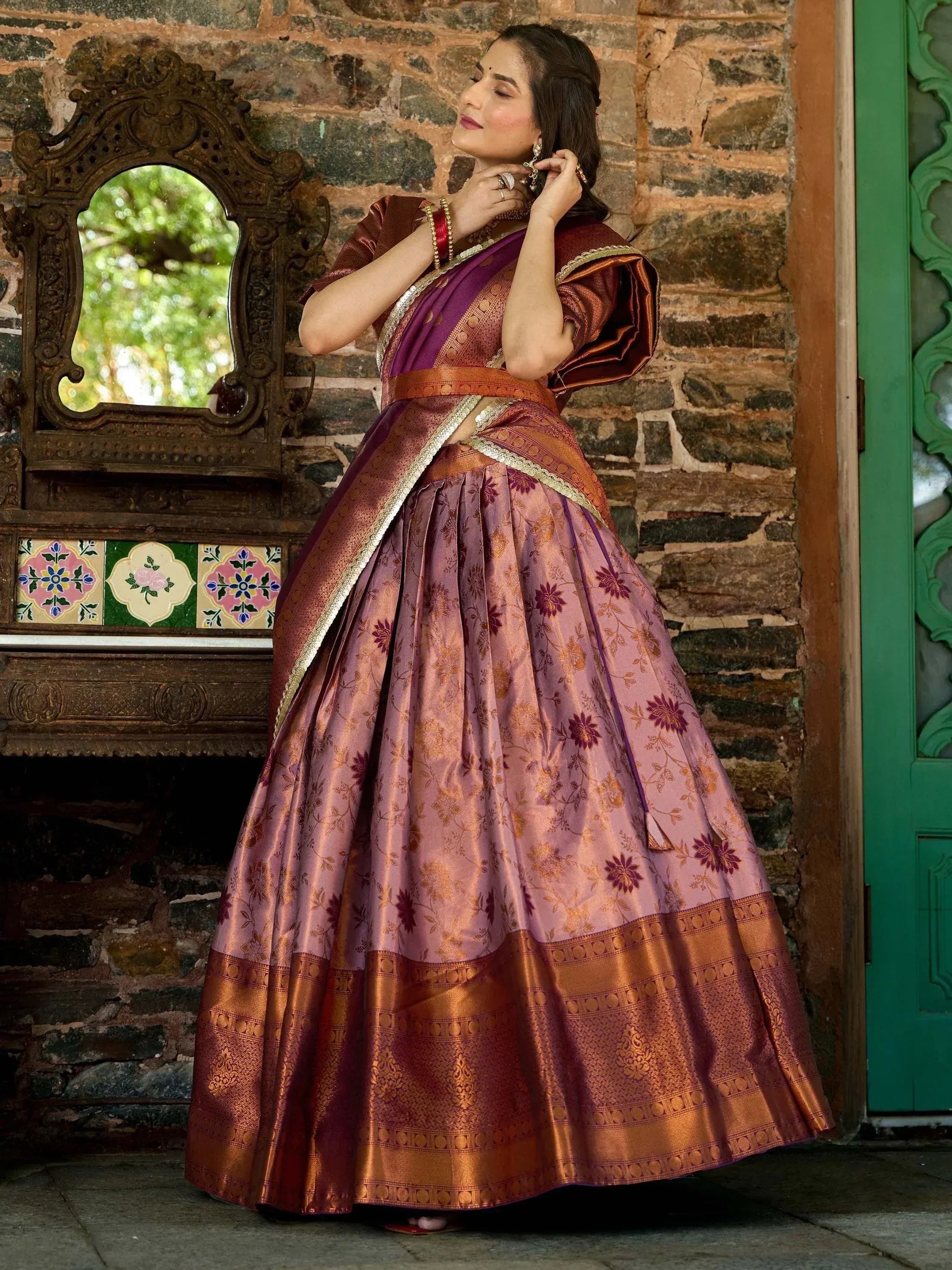 Woman in purple and gold floral lehenga choli with traditional mirror backdrop