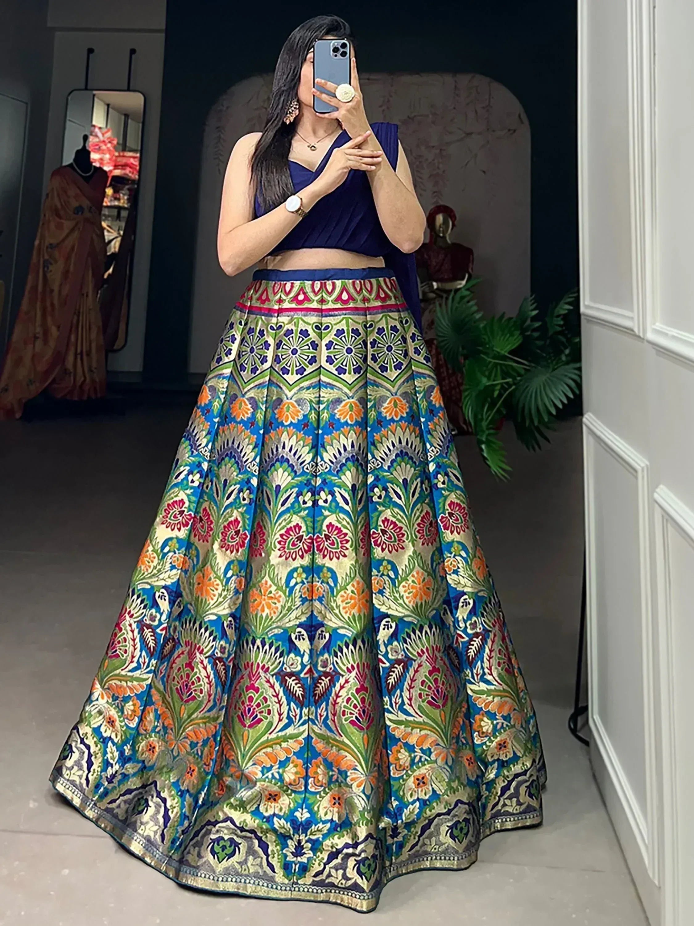 Woman in vibrant floral lehenga choli with blue crop top, perfect for Indian ethnic wear occasions.