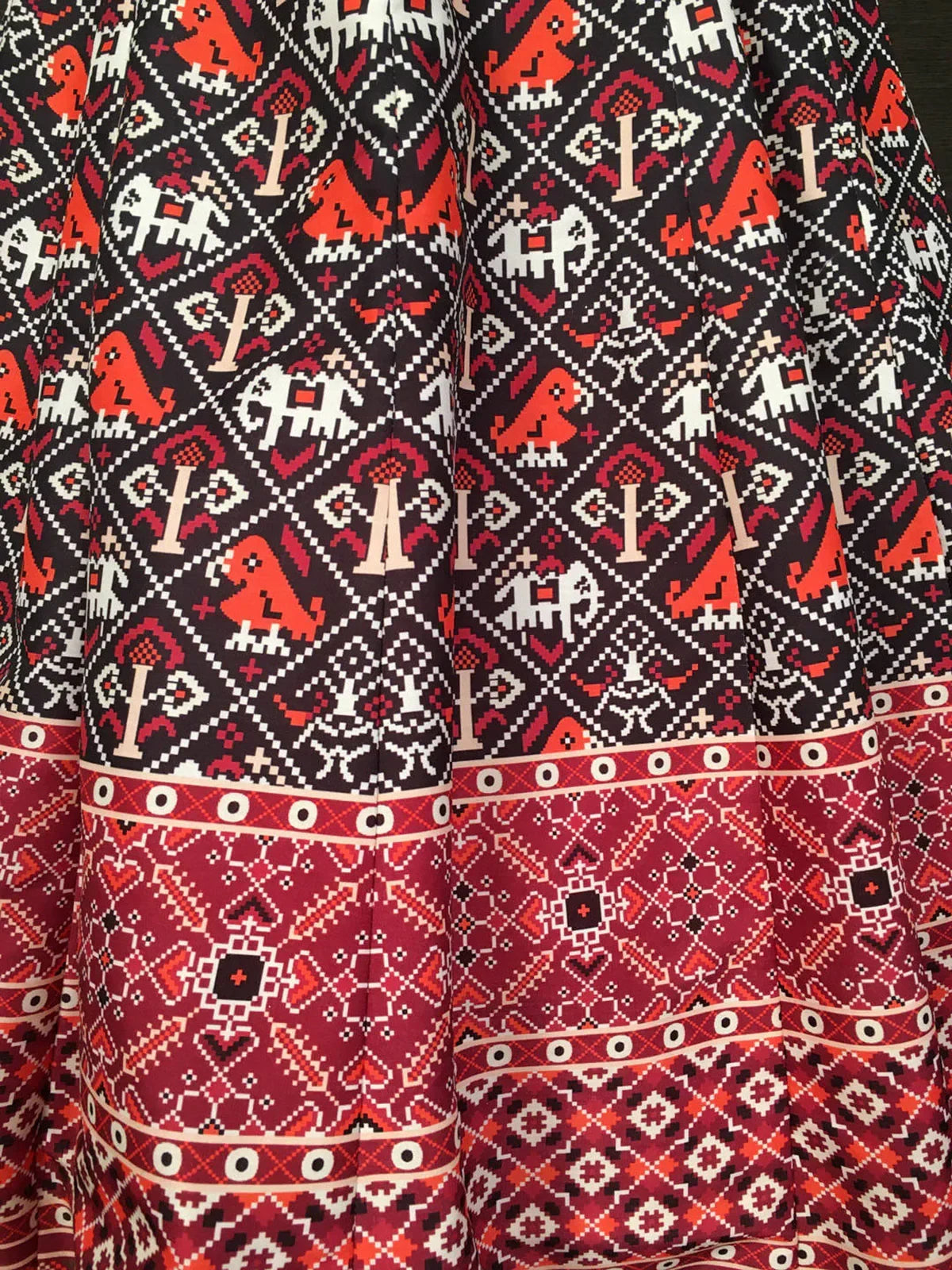 Black and red ethnic lehenga fabric with traditional geometric and elephant print patterns
